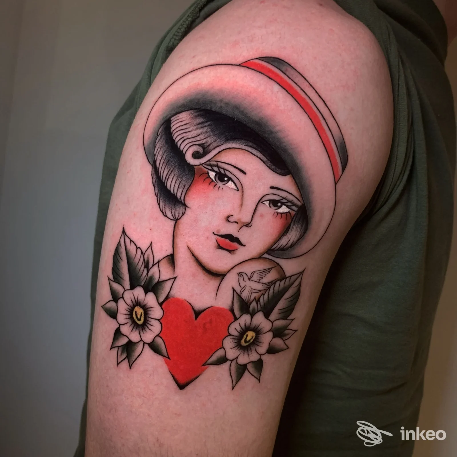 Tatuaggio su alto braccio con ritratto femminile, fiori e cuore rosso — ISTINTO TATTOO STUDIO, Bagheria.