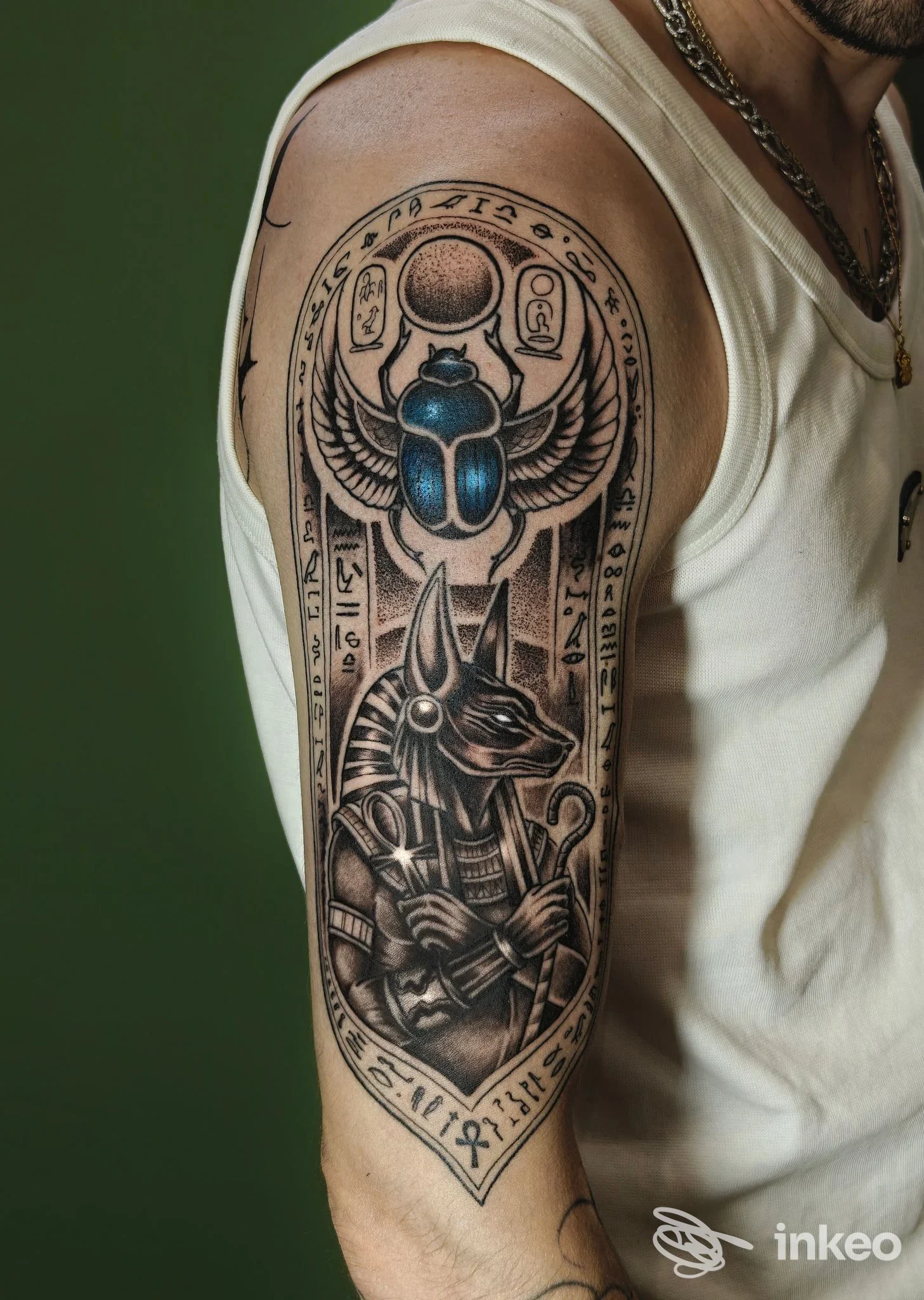 Tatuaggio a tema egizio con scarabeo blu e Anubi sul braccio superiore, foto fornita da Inkspot Studio Tattoo, Tremestieri Etneo.