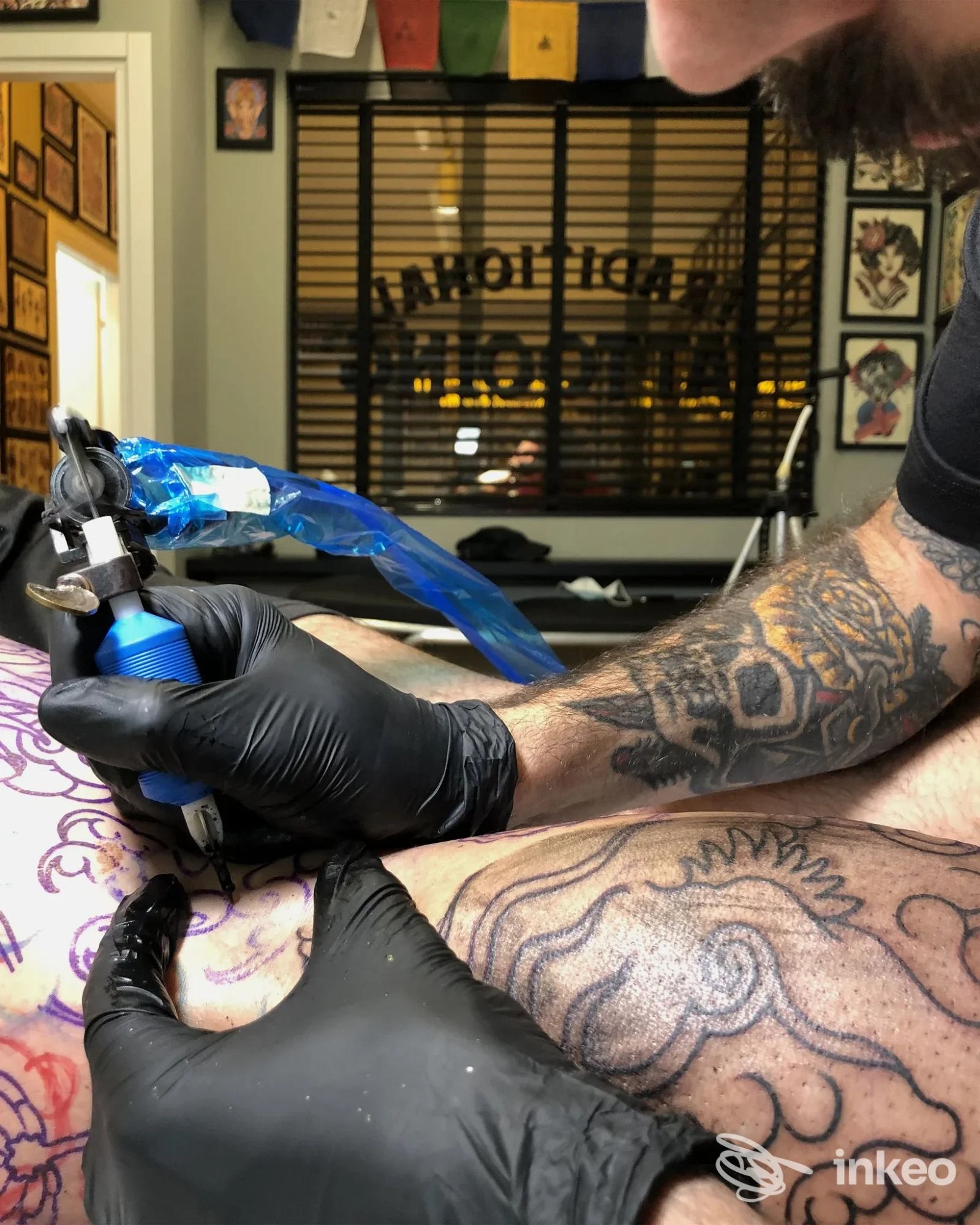 Tatuatore al lavoro su una gamba con motivo ornamentale nello studio JOLLY ROGER TATTOO a Modica.
