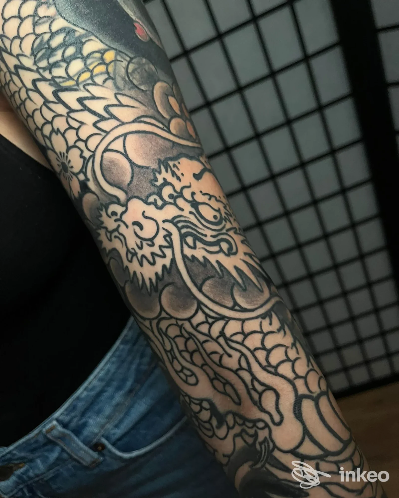 Avambraccio tatuato con ampia manica nera e motivi decorativi; foto fornita da JOLLY ROGER TATTOO, Modica.