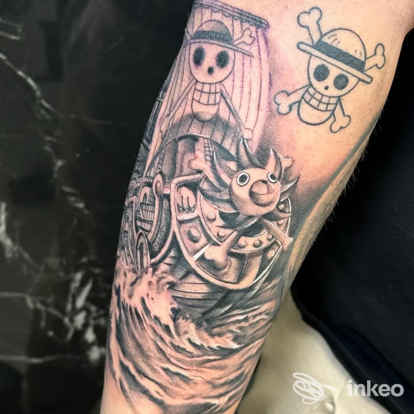 Tatuaggio black & grey sull'avambraccio con soggetti ispirati a One Piece, immagine fornita da Kame House Tattoo Studio, Palermo.