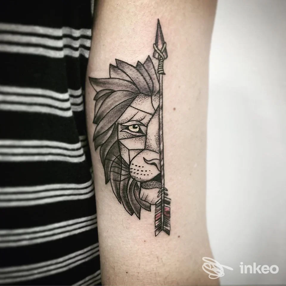 Tatuaggio geometrico di mezzo volto di leone con freccia sull'avambraccio, lavoro di Kraken Tattoo a Gela.