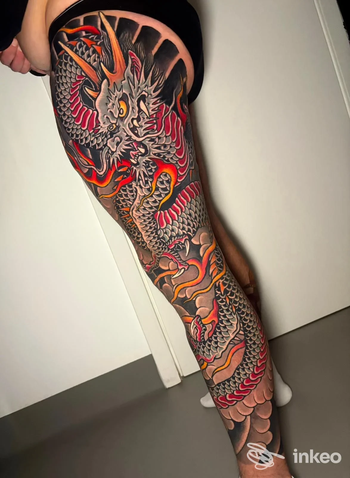 Tatuaggio a manica su gamba con drago in nero, rosso e arancio, foto per Margera Tattoo Studio a Catania.