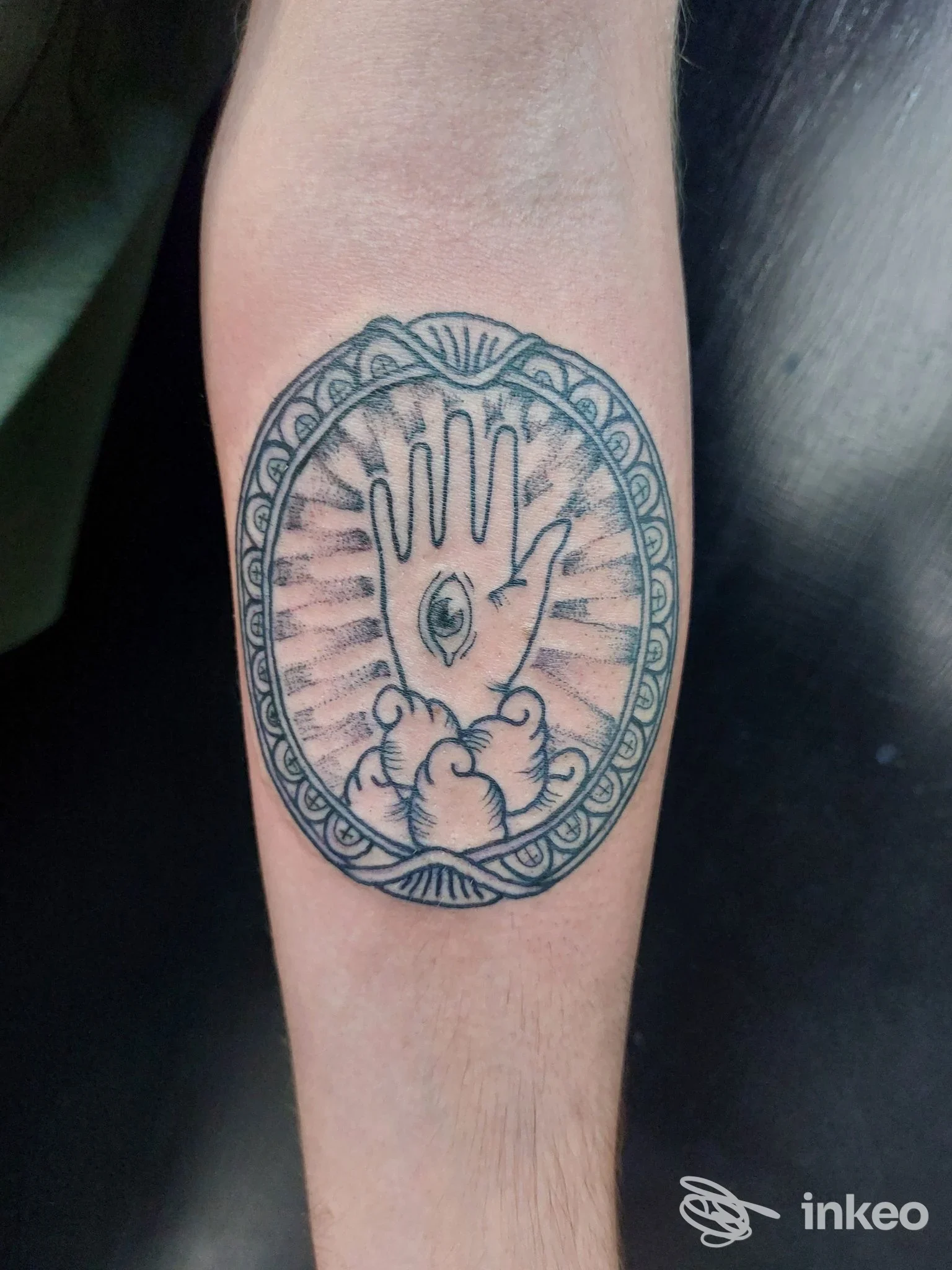 Tatuaggio ovale con mano e occhio al centro sull'avambraccio, scattato per MEDUSA SHOP TATTOO PARLOUR a Palermo.