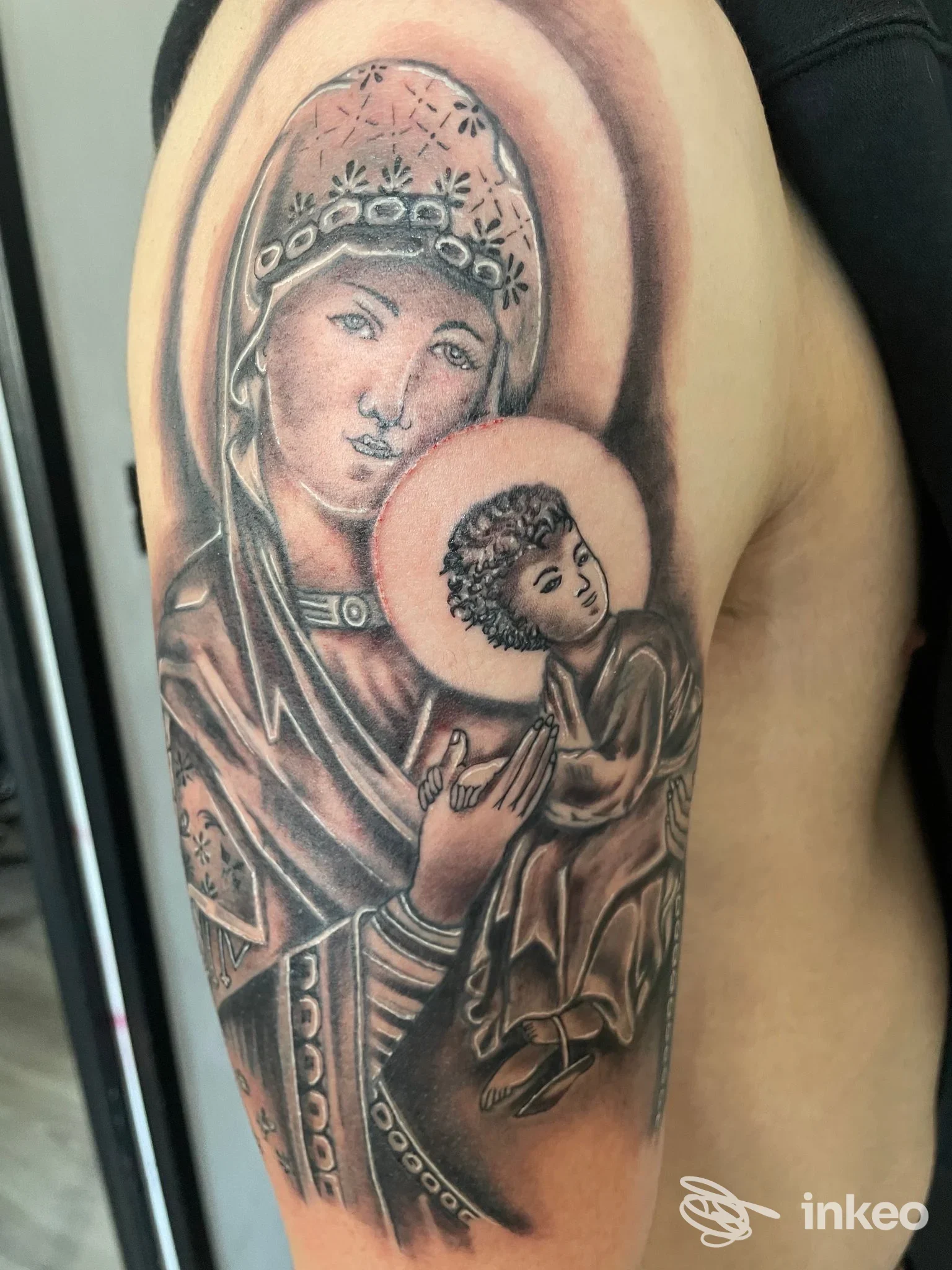 Tatuaggio in bianco e nero della Madonna col Bambino sul braccio, eseguito da N13INK Tattoo Store a Licata.