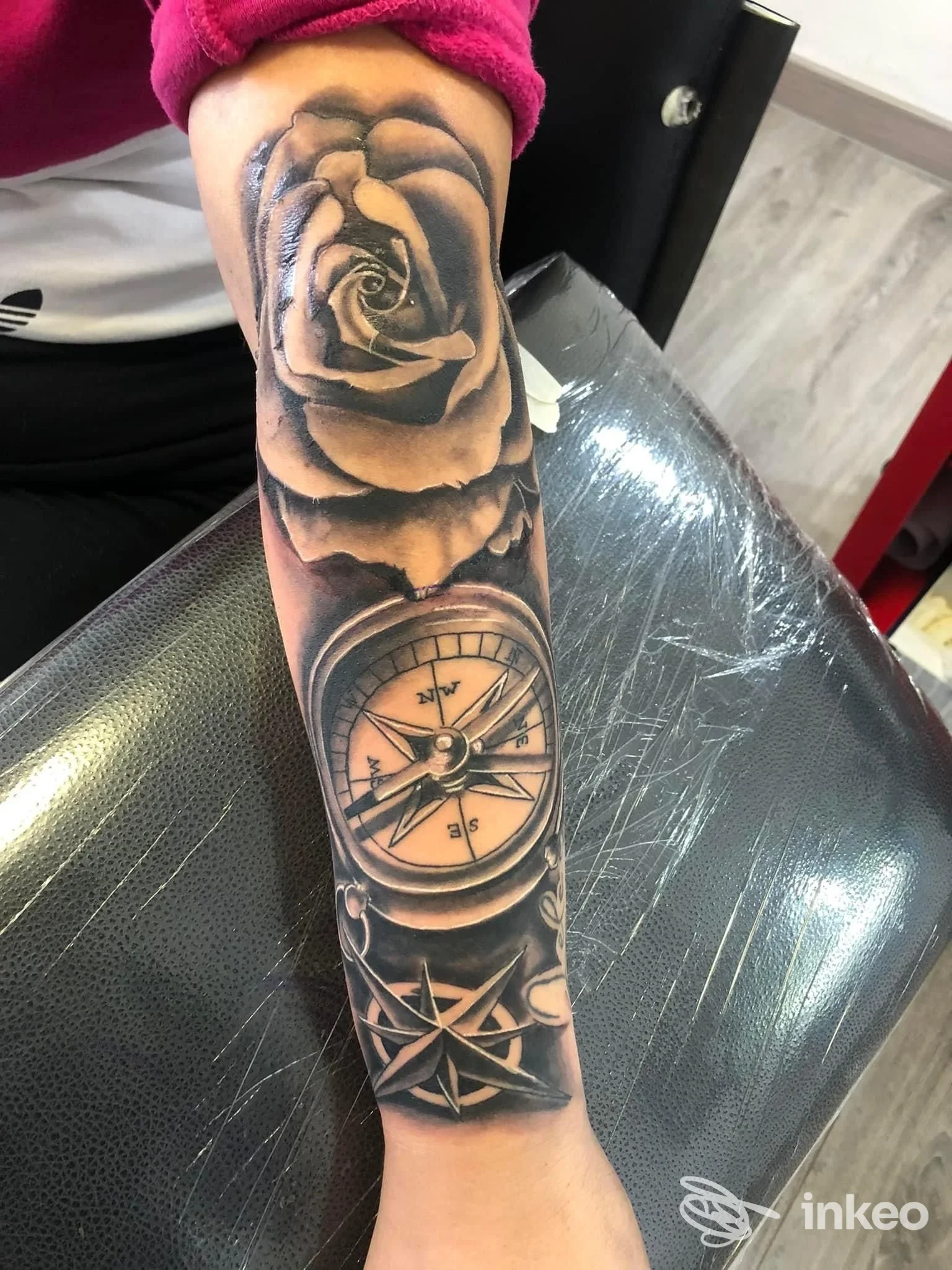 Avambraccio tatuato con rosa, bussola e rosa dei venti; foto dallo studio N13INK Tattoo Store a Licata.
