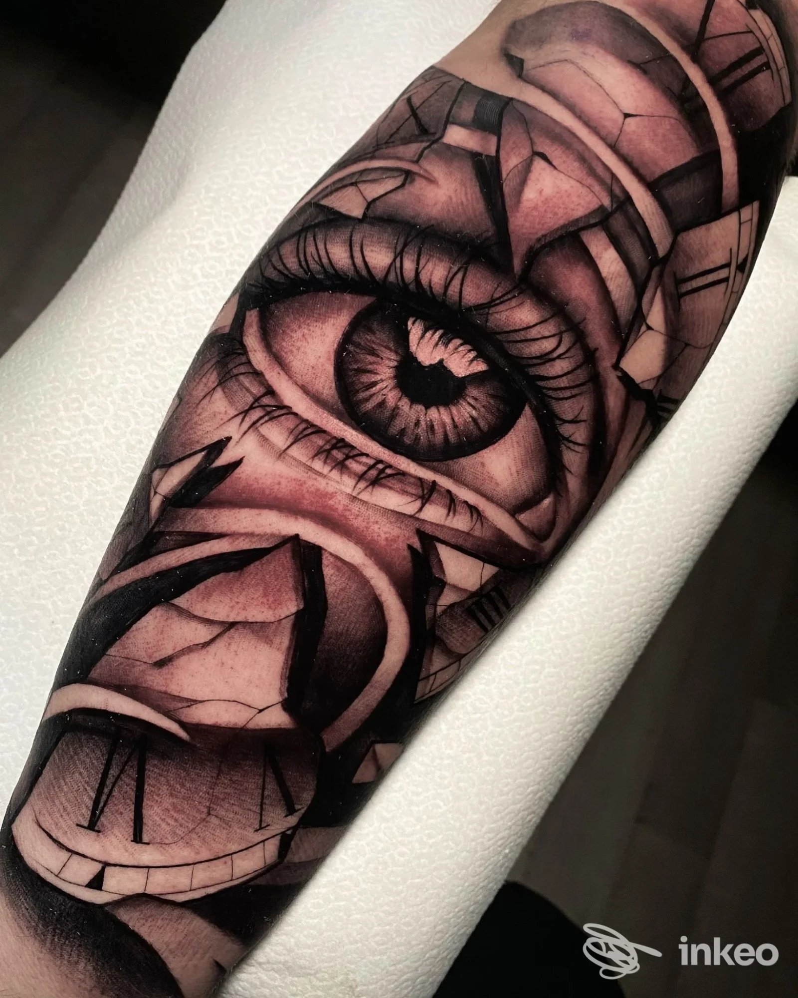 Tatuaggio realistico in bianco e nero su avambraccio raffigurante un occhio e elementi di orologio, NOCCHE DURE TATTOO STUDIO, Modica.