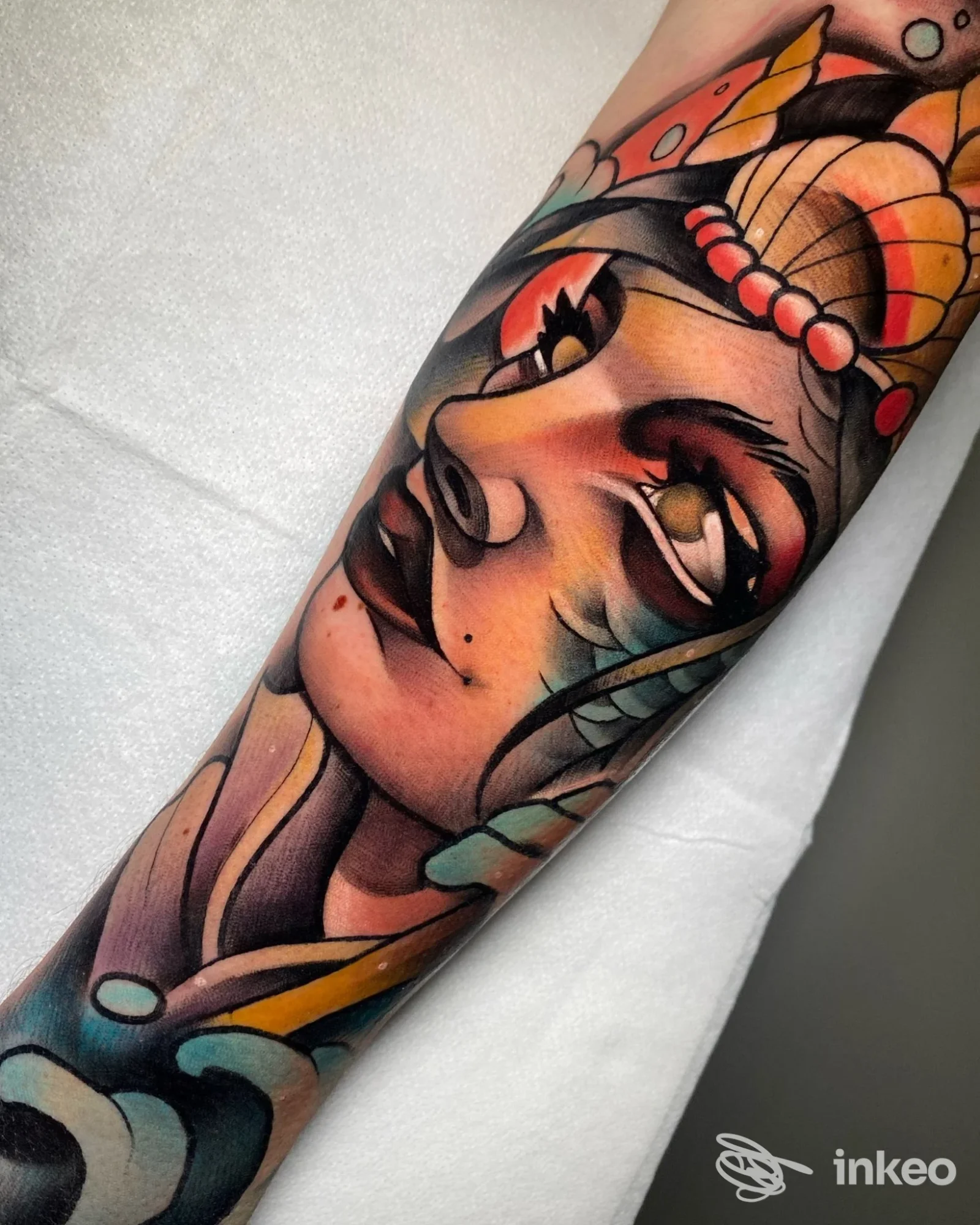 Tatuaggio a colori su avambraccio con volto stilizzato e elementi decorativi, realizzato da NOCCHE DURE TATTOO STUDIO a Modica.