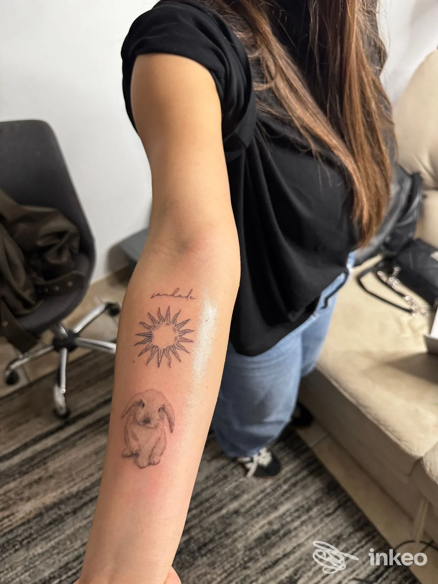 Avambraccio con due tatuaggi freschi: sole stilizzato e piccolo coniglio, foto scattata nello studio Nemesis Tattoo Studio a Palermo.