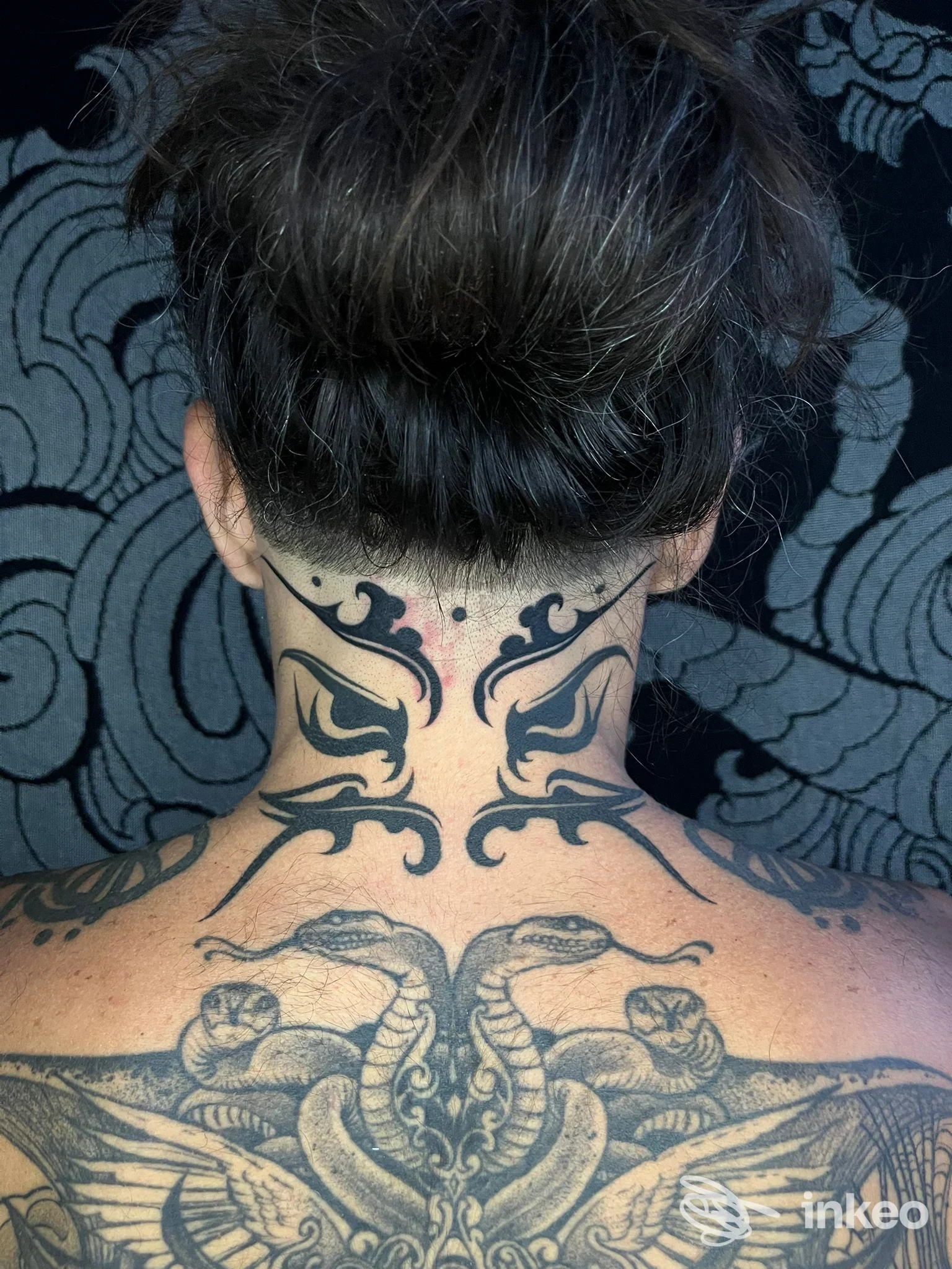 Tatuaggio nero su nuca e parte alta della schiena, foto inviata da Nerho Tattoo Palermo.