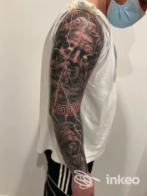 Manica tatuata realistico in bianco e nero su spalla e avambraccio destro, foto di profilo. Perfecto Tattoo Studio, Vittoria.