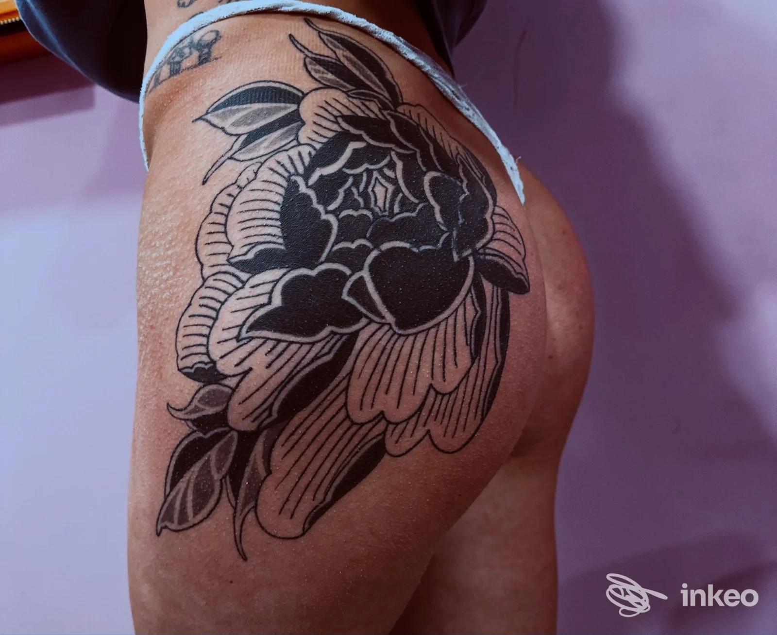 Fotografia di un ampio tatuaggio floreale nero su fianco e gluteo, scattata per Plh’s factory - Tattoo Tatuaggi e Piercing a Piazza Armerina.