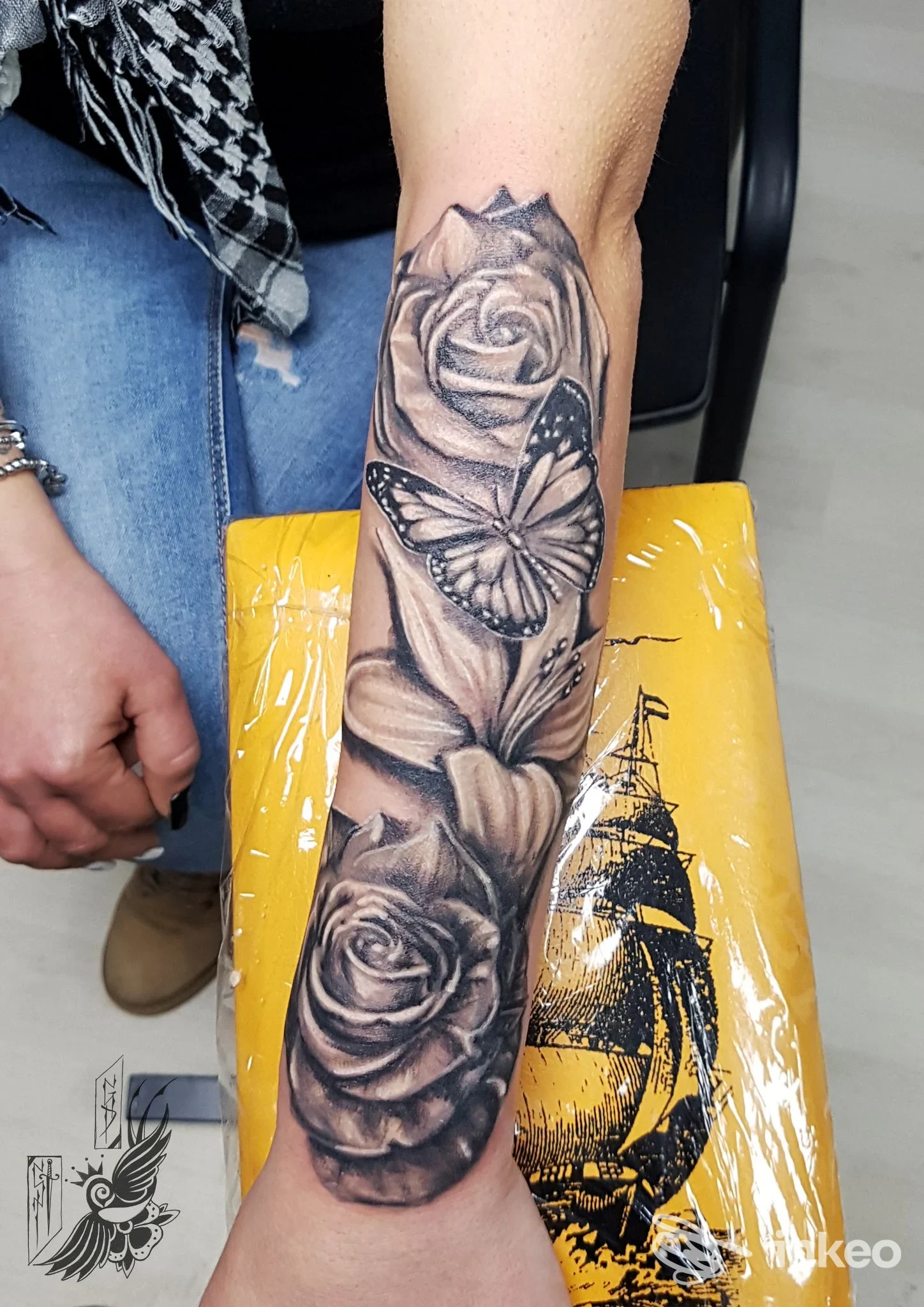 Avambraccio con tatuaggio realistico di rose e farfalla in bianco e nero, eseguito da Secondapelle Tattoo a Ragusa.