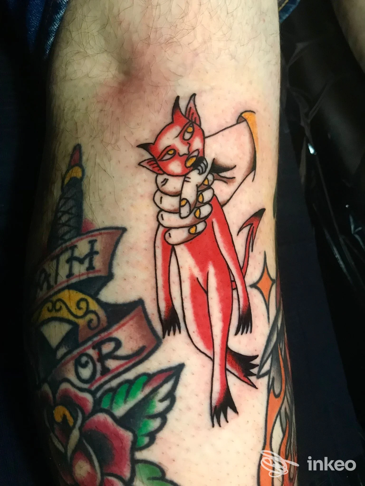 Tatuaggio su avambraccio con gatto rosso stilizzato tenuto da una mano, Sideshow Studio Piercing & Tattoo, Catania.