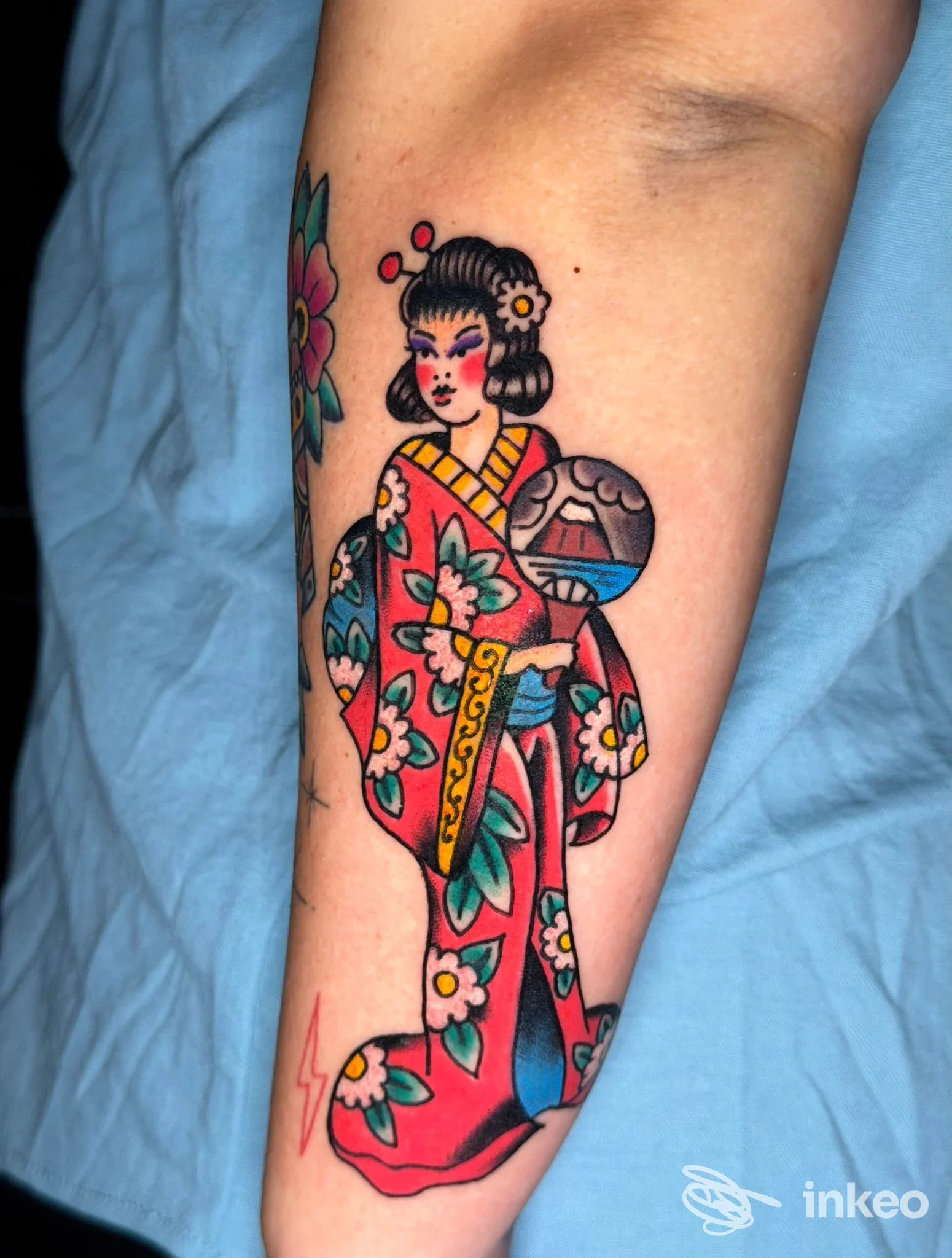 Tatuaggio colorato di una geisha in stile tradizionale sull'avambraccio, realizzato da Sideshow Studio Piercing & Tattoo, Catania.