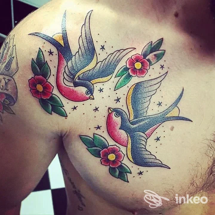 Due rondini colorate e fiori tatuati sul petto, foto del lavoro dello studio Skin Tattoo di La Rocca Adriano a Giardini-Naxos.