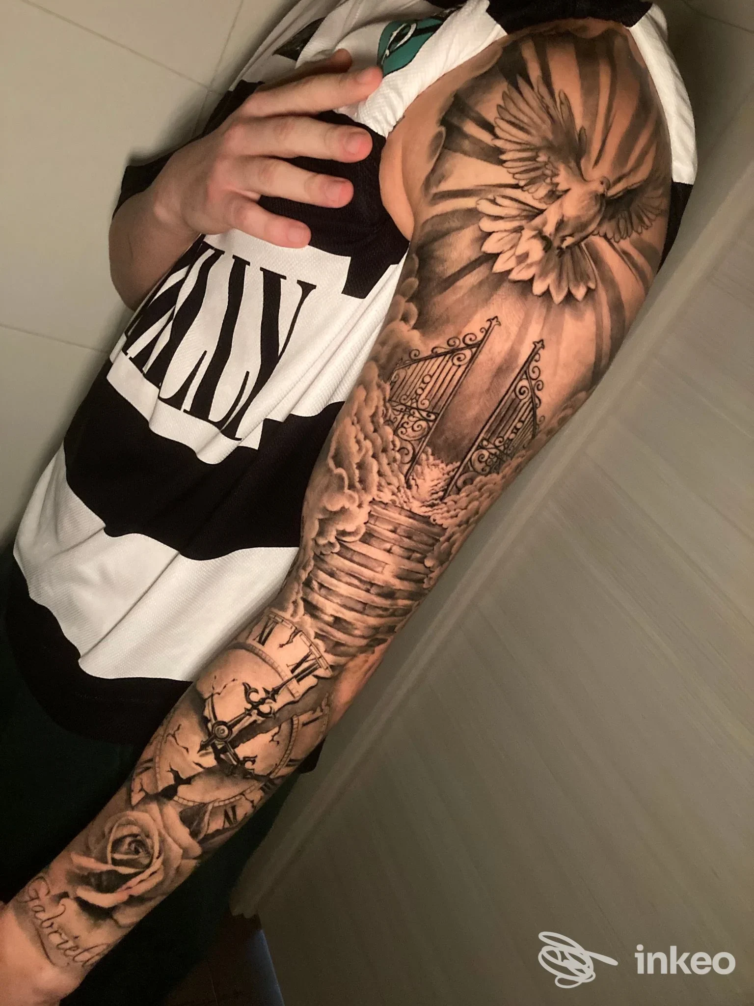 Manica tatuata in bianco e nero con colomba, cancelli e rose, foto di Smith Tattoo Shop a Catania.