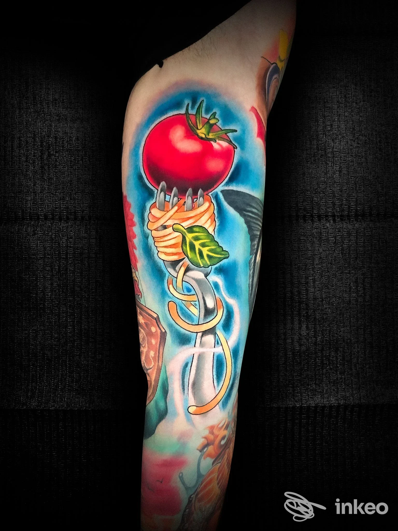 Tatuaggio colorato su avambraccio con un pomodoro su una forchetta avvolta di spaghetti, immagine proveniente da Spaceinktattoo, Milazzo.