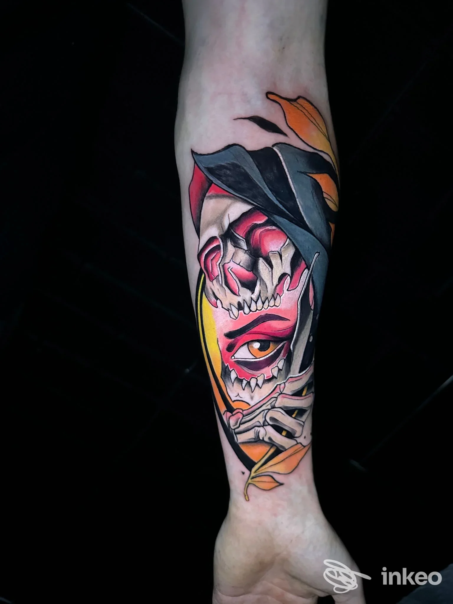 Tatuaggio colorato su avambraccio con volto stilizzato e foglie, Strano Tattoo, Catania.