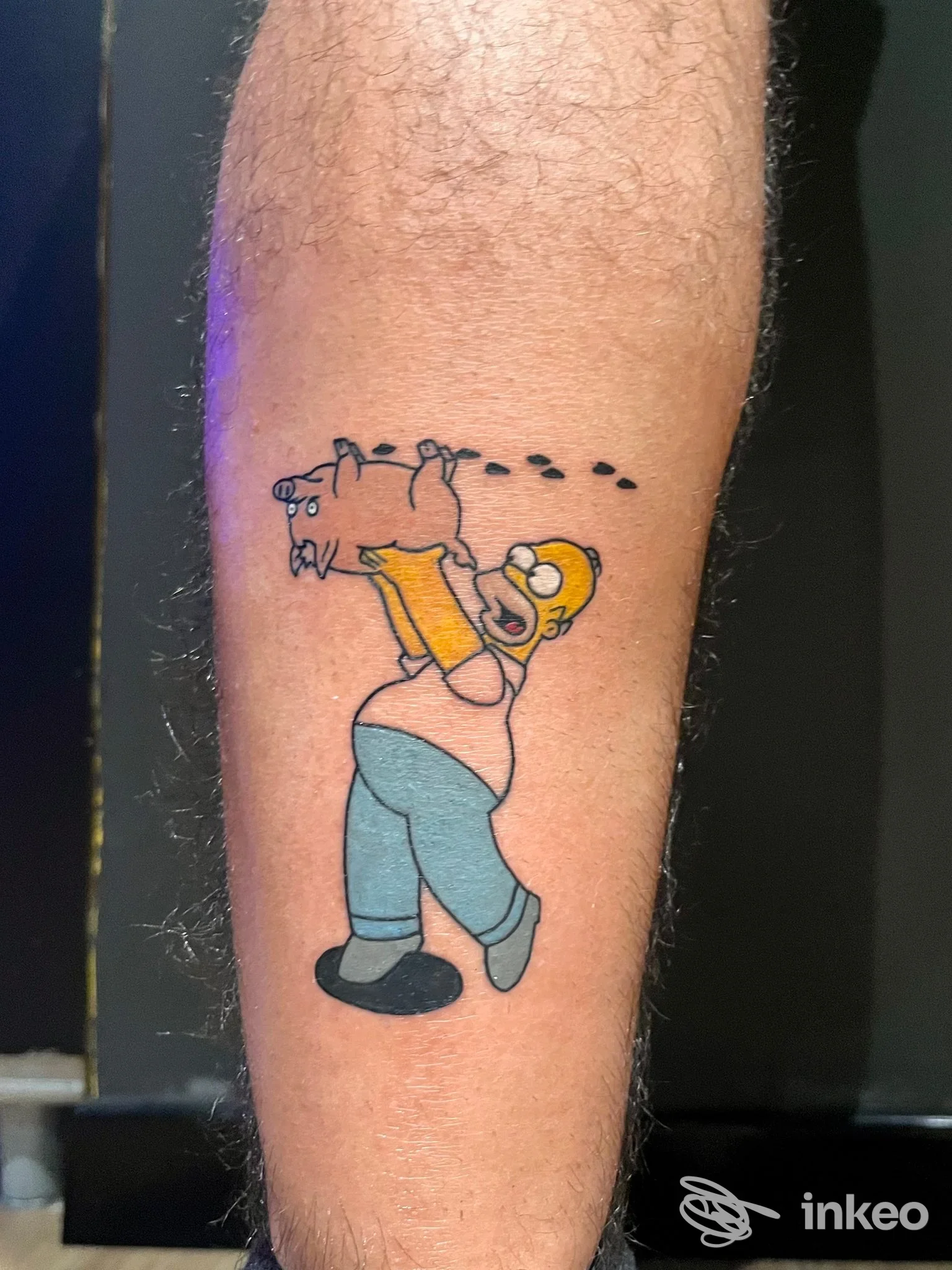 Tatuaggio colorato su avambraccio: Homer Simpson che solleva un maialino. THE GOOD FELLAS TATTOO, Palermo.