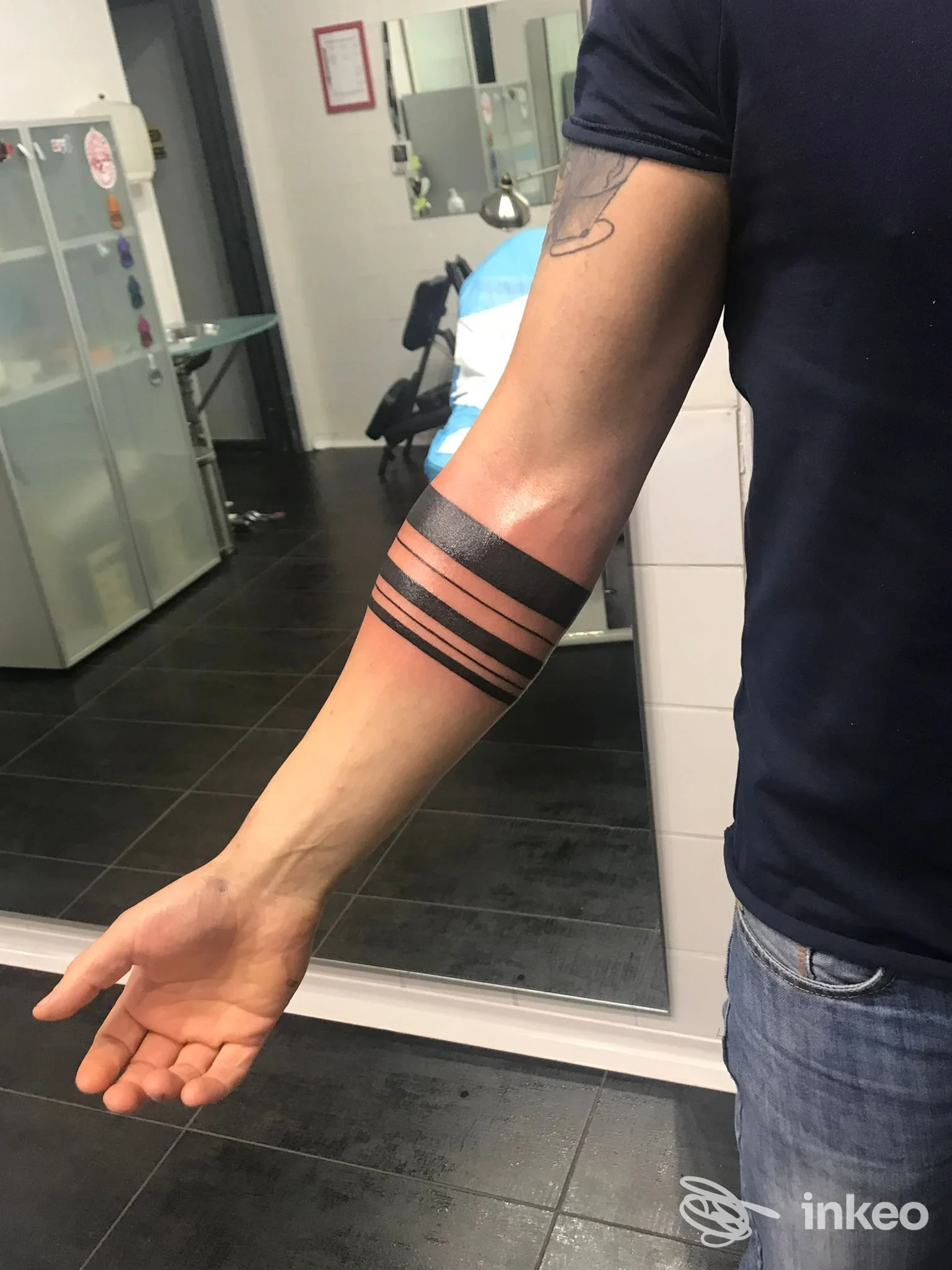 Tatuaggio a bracciale con bande nere sull'avambraccio, fotografia scattata in studio. Tahiti Tattoo, Catania.