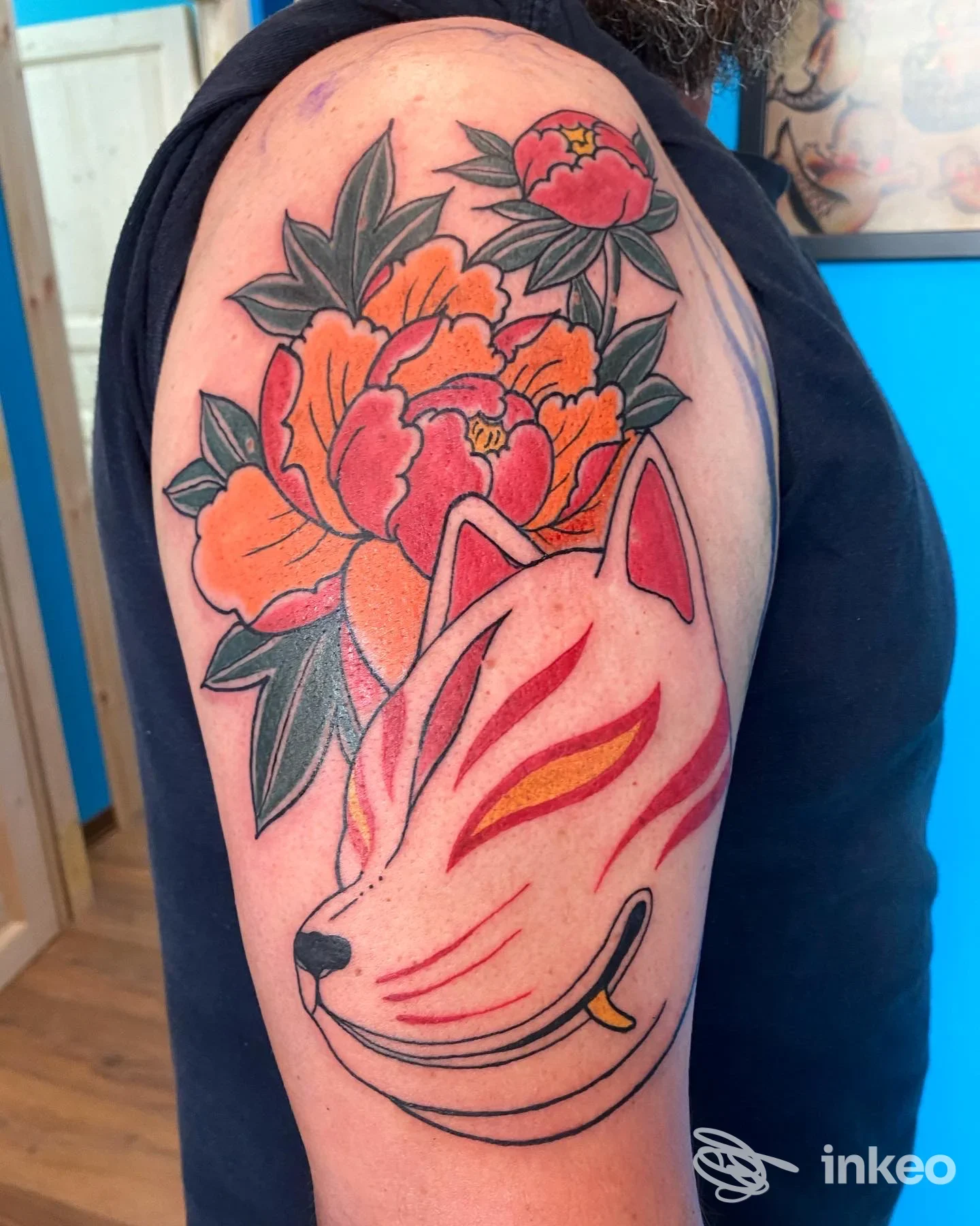 Tatuaggio su braccio con maschera kitsune e peonie colorate, lavoro fotografato dallo studio THE INK ROOM TATTOO SHOP Catania.