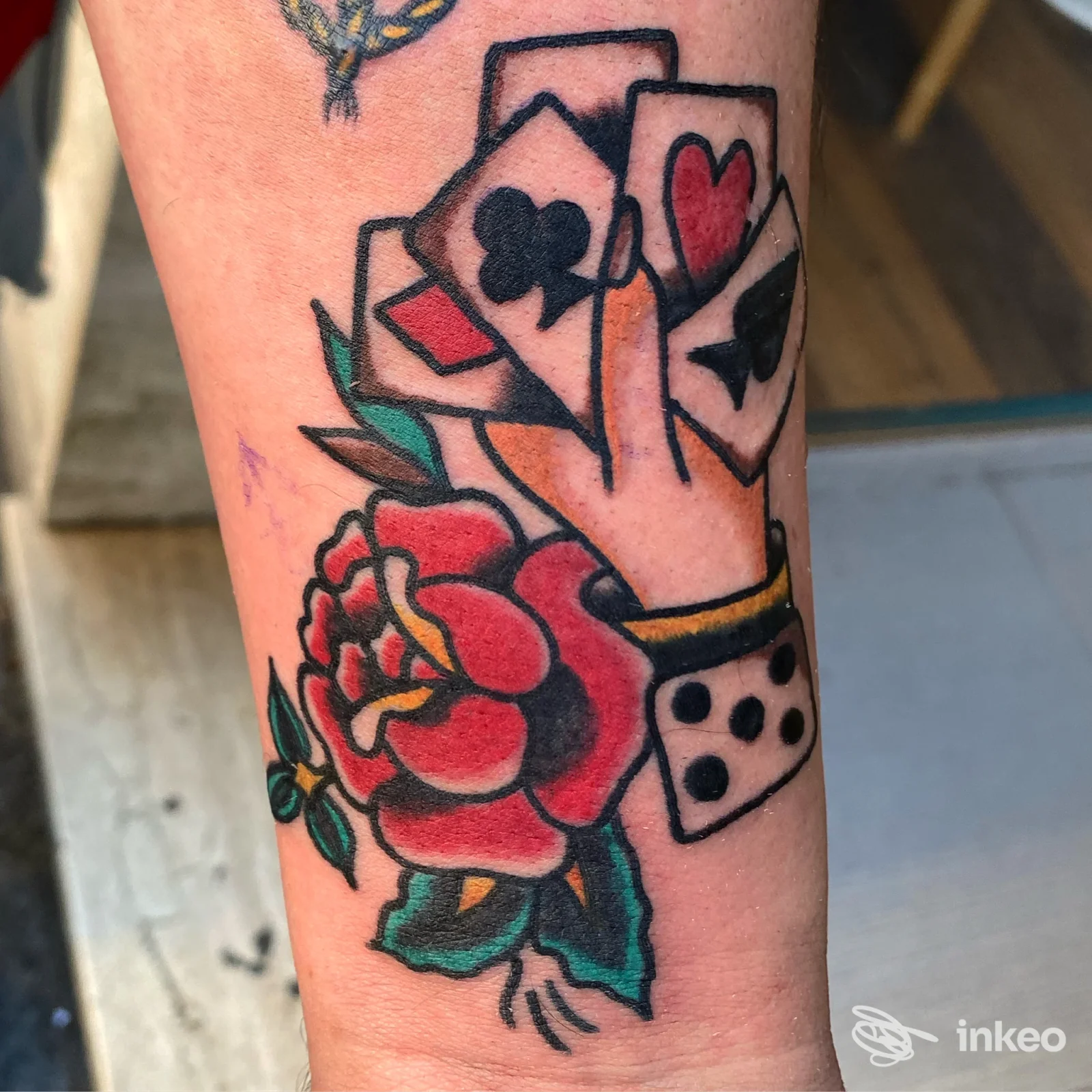 Tatuaggio a colori sull'avambraccio con rose e carte da gioco — THE INK ROOM TATTOO SHOP, Catania.