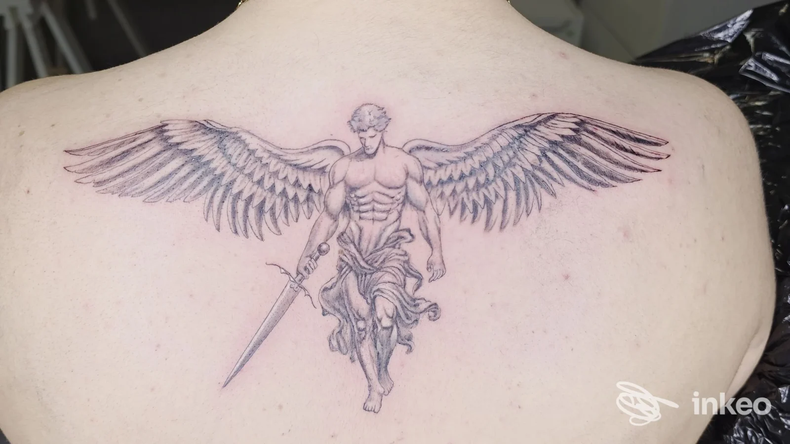 Tatuaggio su scapole: figura alata con spada in stile black&grey eseguito da Tahiti Tattoo di Fabio La rocca, Nicolosi.