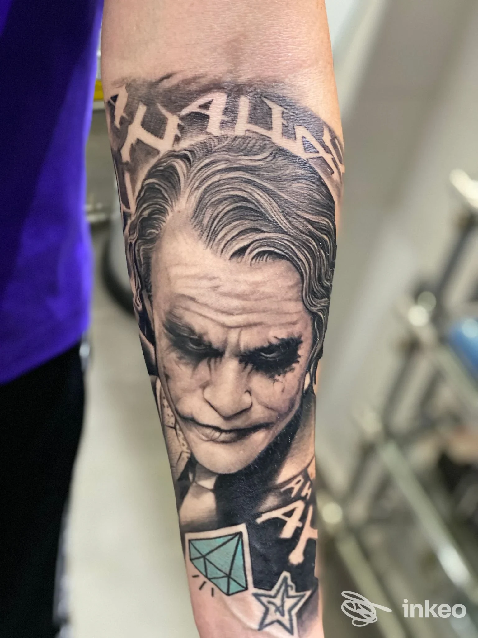 Tatuaggio realistico in bianco e nero del volto del Joker sull'avambraccio, realizzato da Tattoo e Piercing I colori dell'anima a Palermo.