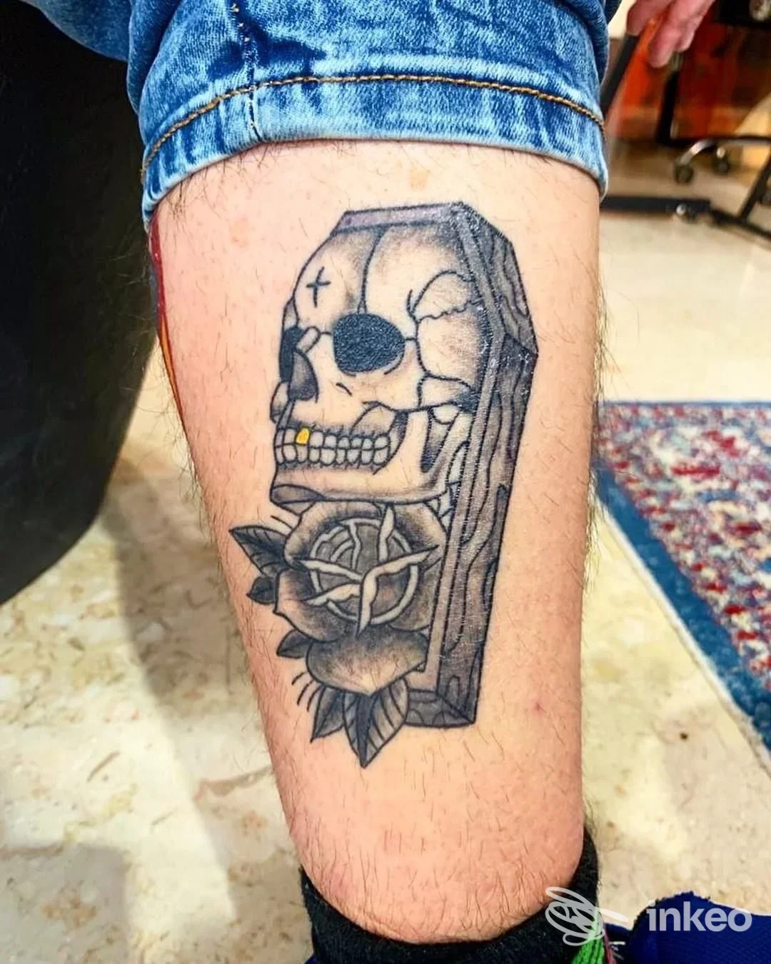 Tatuaggio sul polpaccio raffigurante un teschio in una bara con rosa e nodi, lavoro realizzato da Tatuaggi David Ink a Trapani.