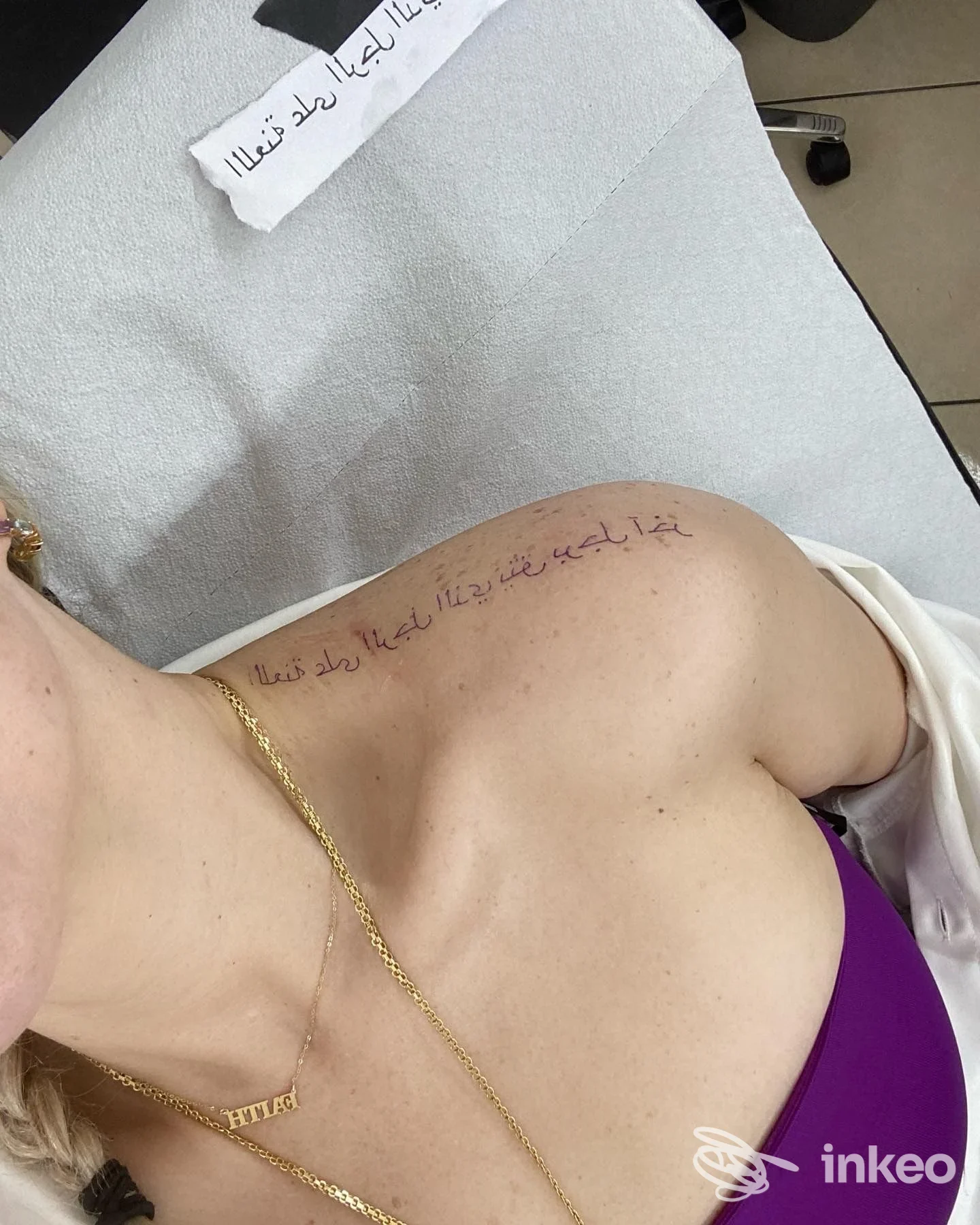 Bozza di scritta tatuata sulla pelle in corrispondenza di clavicola e spalla; foto fornita dallo studio The Queen Of Tattoo Tatuaggi E Piercing, Catania.