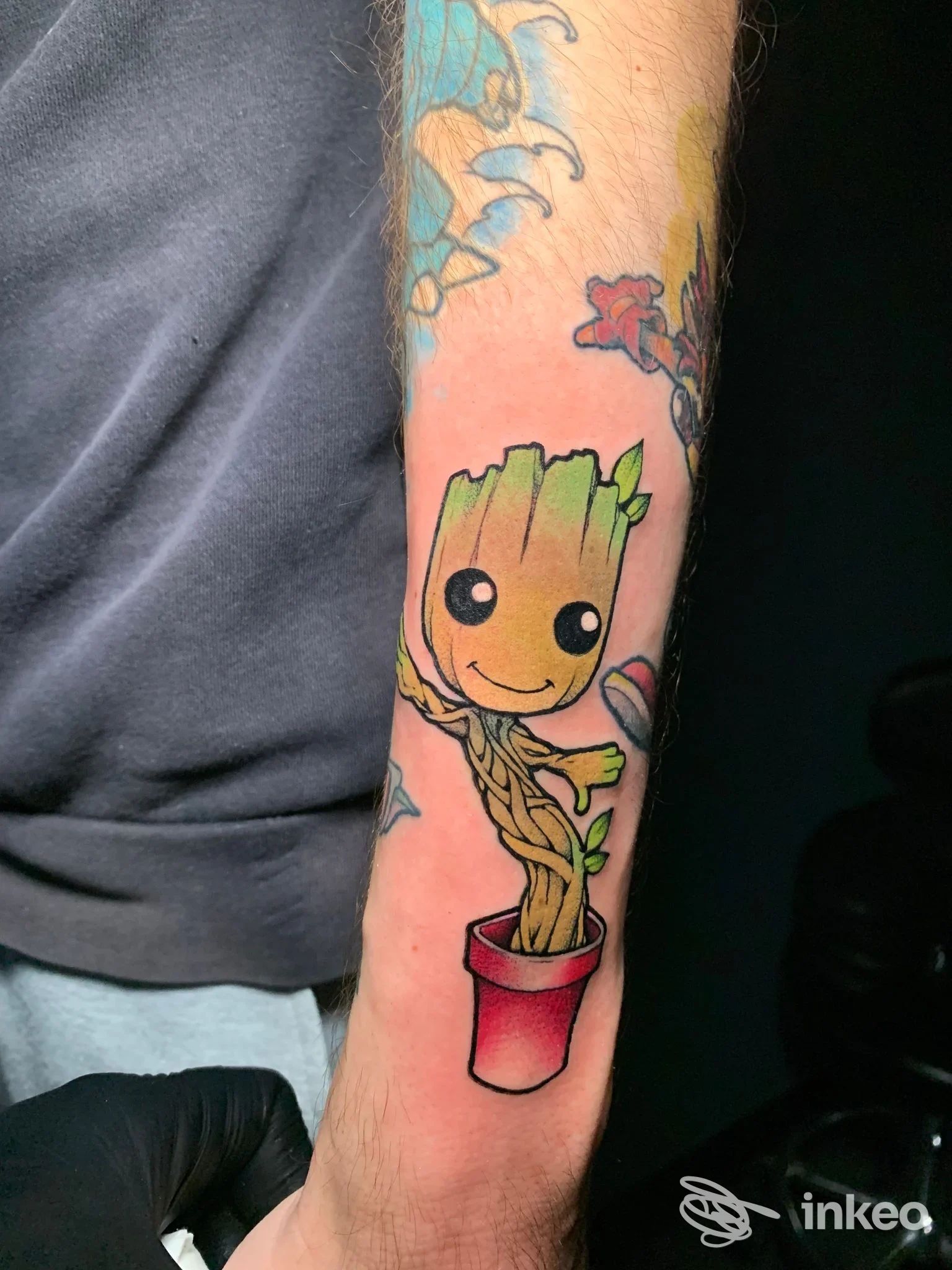 Tatuaggio colorato raffigurante Baby Groot in un vaso sul lato interno dell'avambraccio, eseguito da The Kingdom Tattoo a Cefalù.