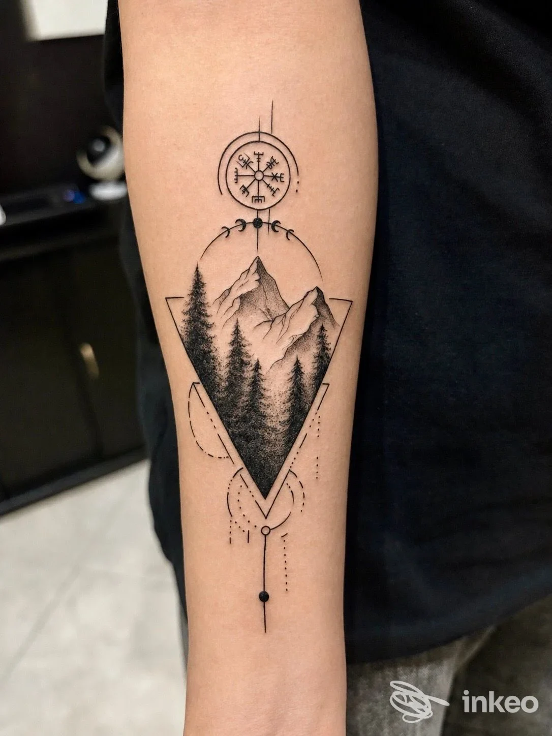 Tatuaggio geometrico di montagne e alberi sull'avambraccio, eseguito da Tomodachi Tattoo Studio a Mazara del Vallo.