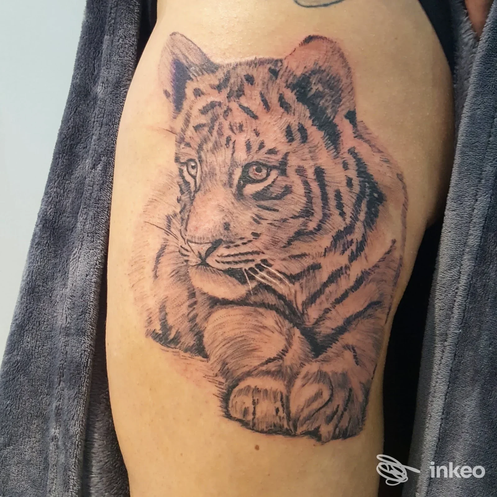 Tatuaggio realistico in bianco e nero di una tigre sul braccio, opera di Ttinko Studio Tattoo, Comiso.