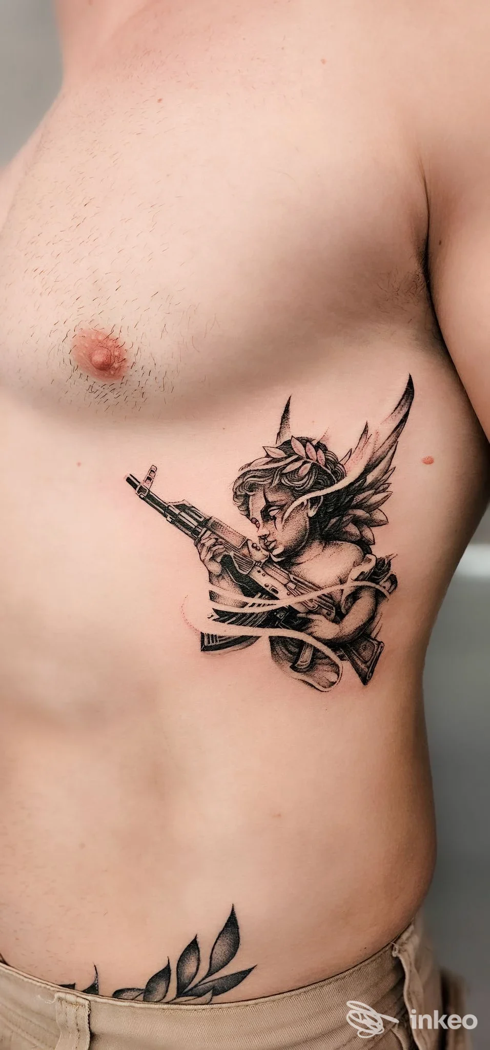 Tatuaggio black & grey su fianco destro raffigurante figura alata con fucile, foto fornita da The King Tattoo Studio, Messina.