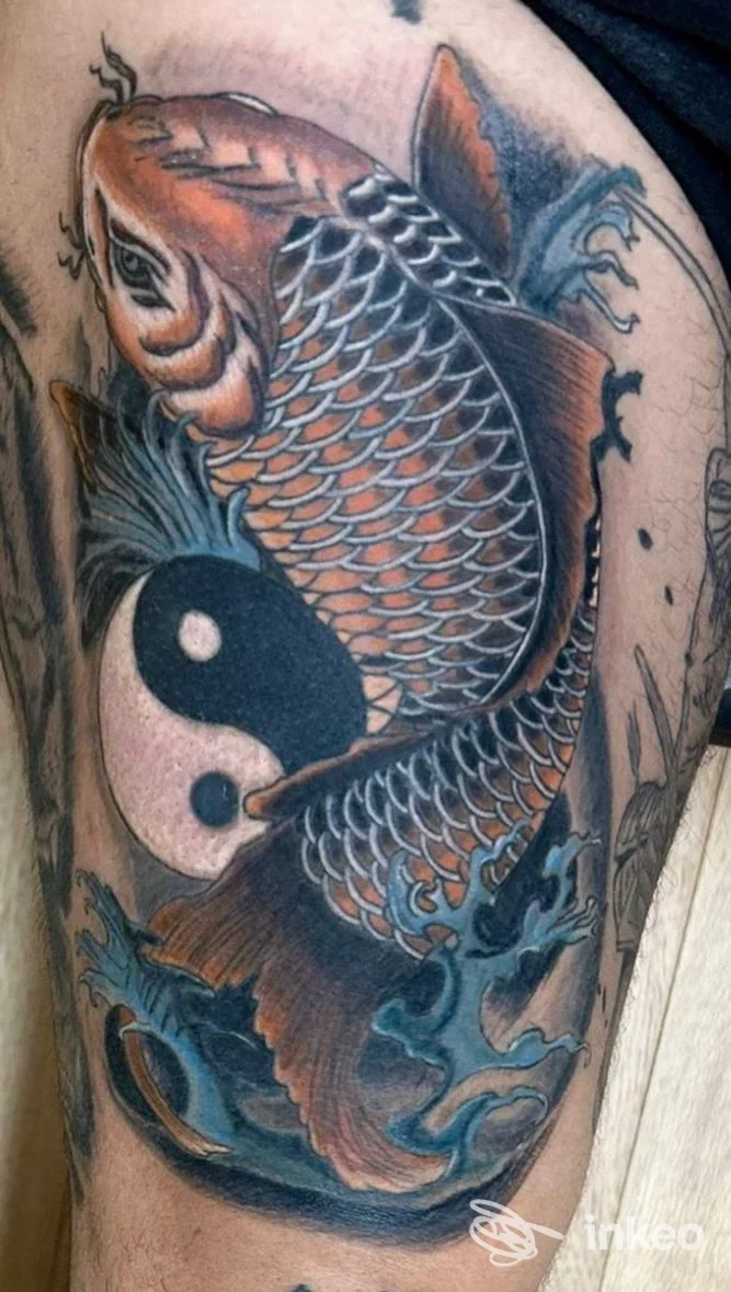 Tatuaggio di carpa koi con yin-yang e onde blu sul braccio, realizzato da Vali Tattoo & Bodypiercing a Catania.