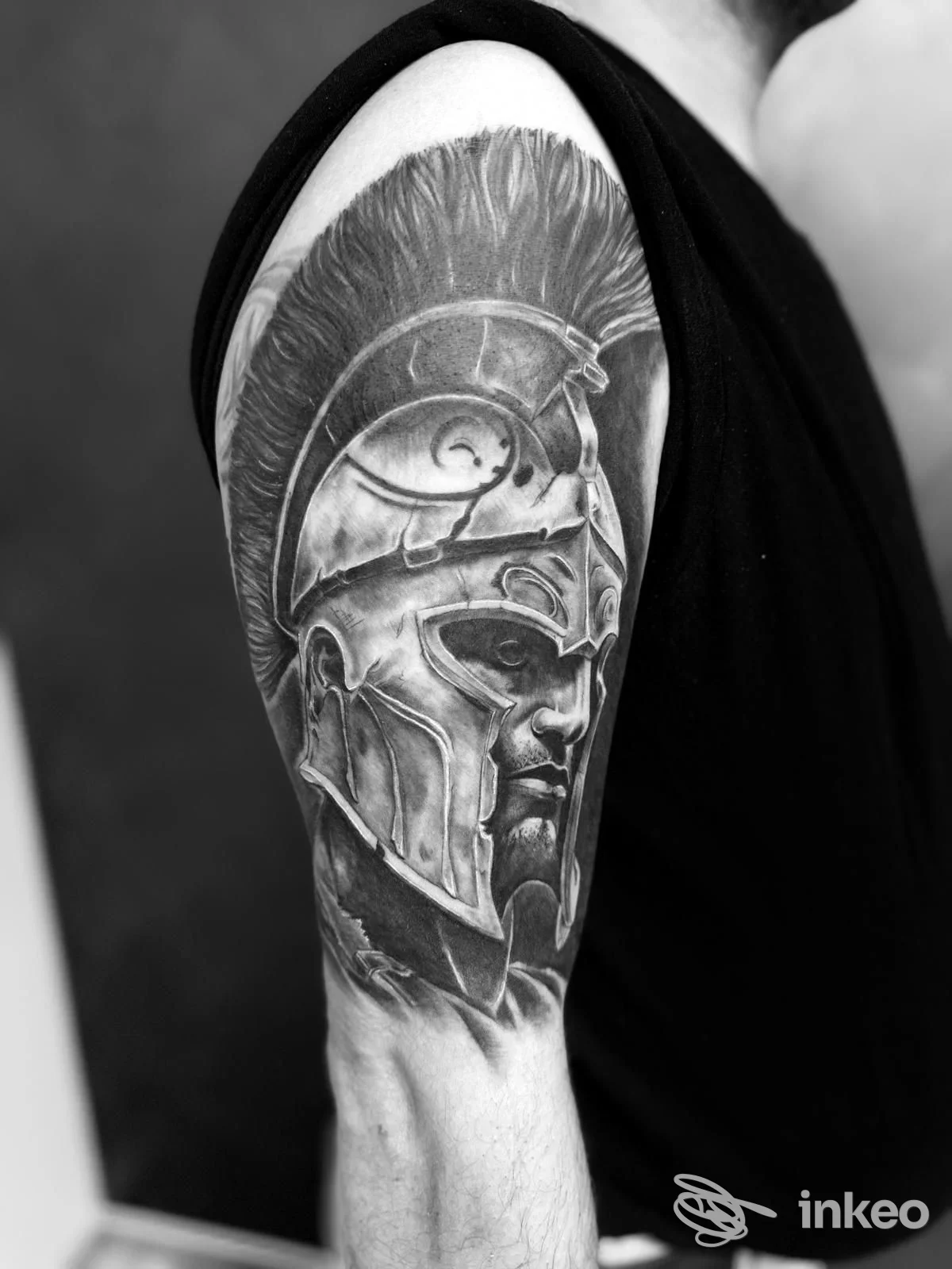 Tatuaggio realistico in bianco e nero di un guerriero con elmo sul braccio superiore, Emy Tattoo di Francesco Ciavolino, Pietraperzia.
