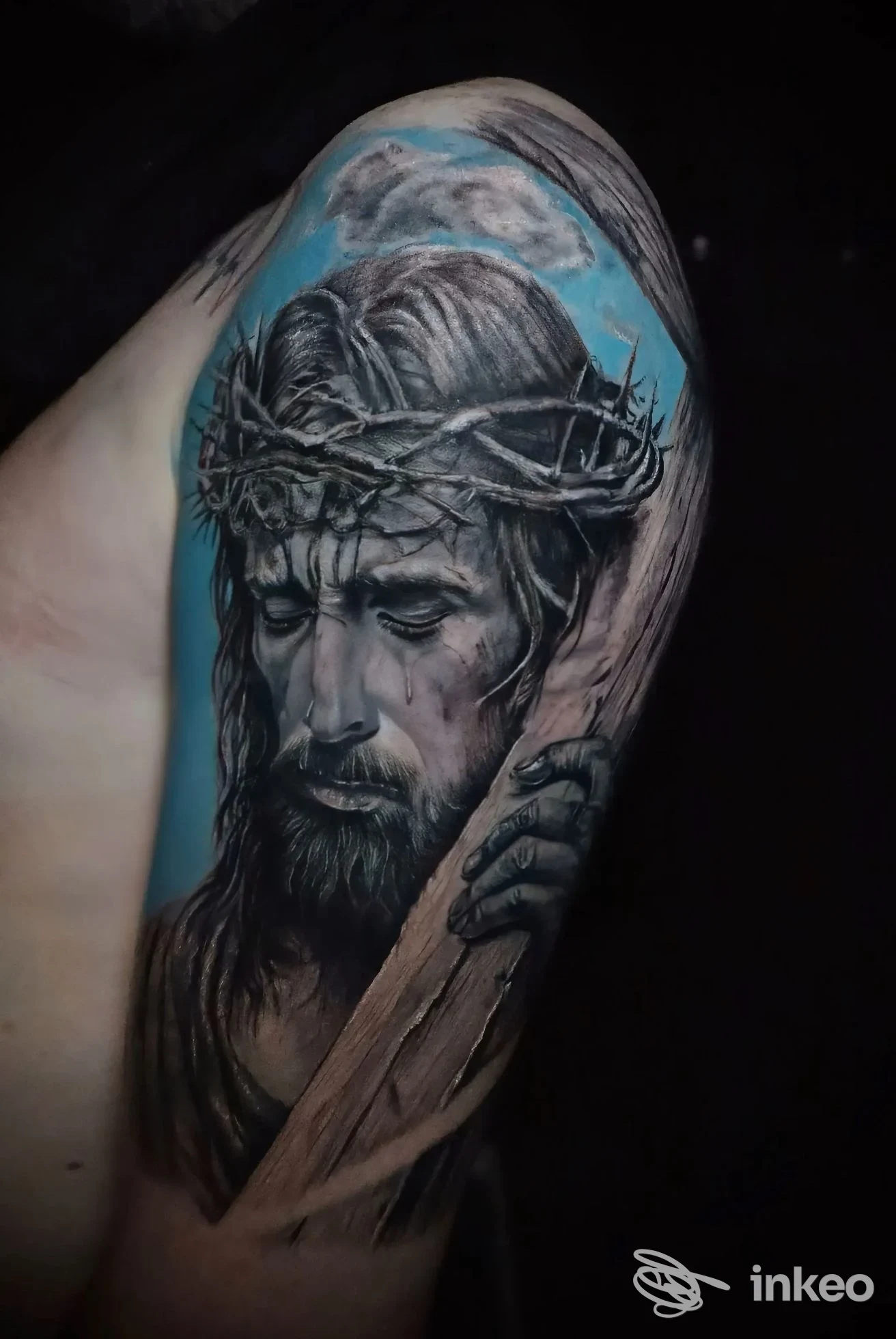 Tatuaggio realistico del volto di Gesù con corona di spine sul bicipite, lavoro di SM tattoo art stefano mazzone, Carlentini Nord.