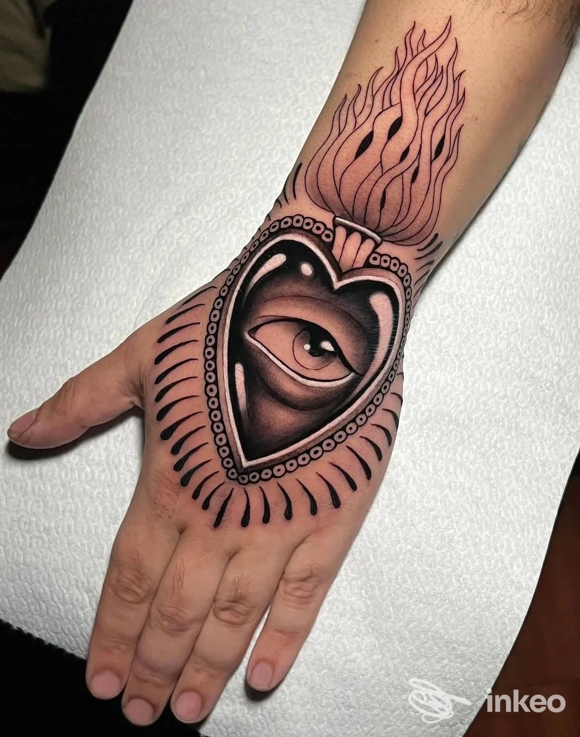 Tatuaggio grande sul dorso della mano con cuore e occhio stilizzato, scatto di Pandemonium tattoo studio, Palermo.