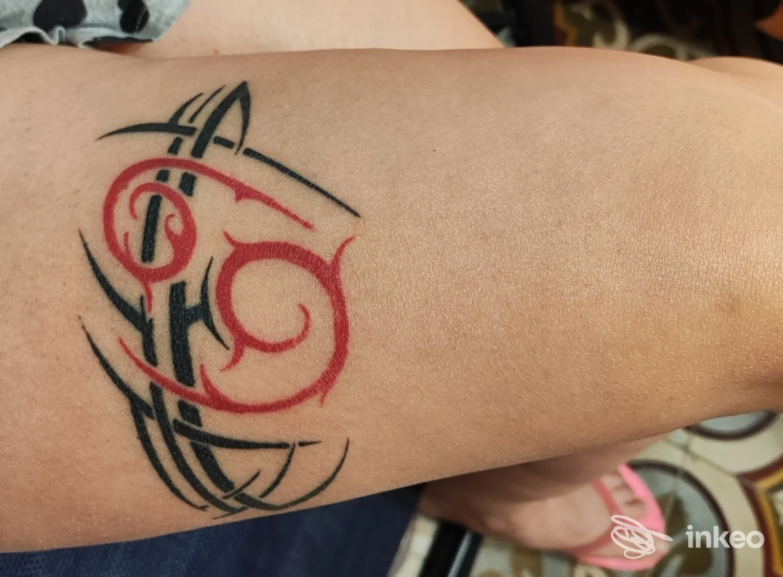 Tattoo tribale in nero e rosso sull'avambraccio sinistro, fotografia dettagliata della realizzazione. Studio TATTOOGARAGE, Trapani.