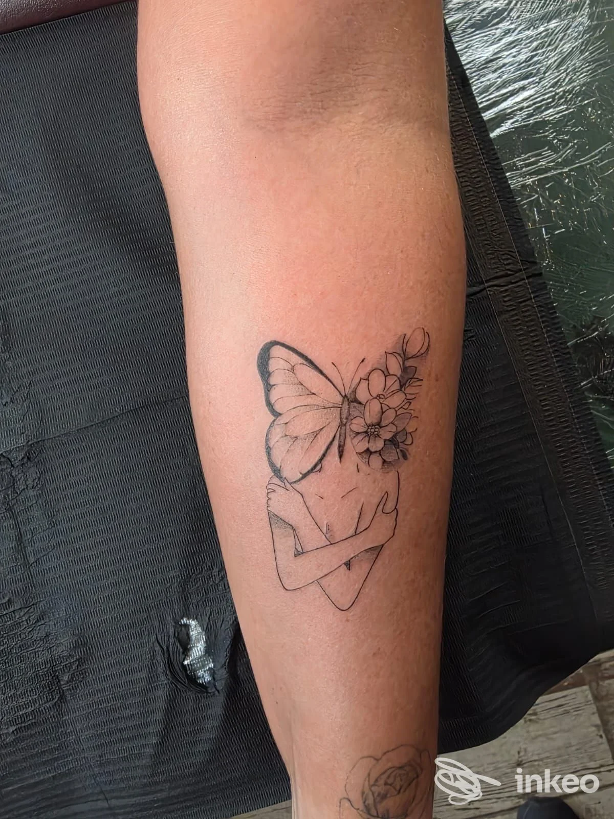 Tatuaggio su avambraccio con figura femminile stilizzata e farfalla al posto del volto, immagine fornita dallo studio VS Narashima Tattoo, Messina.