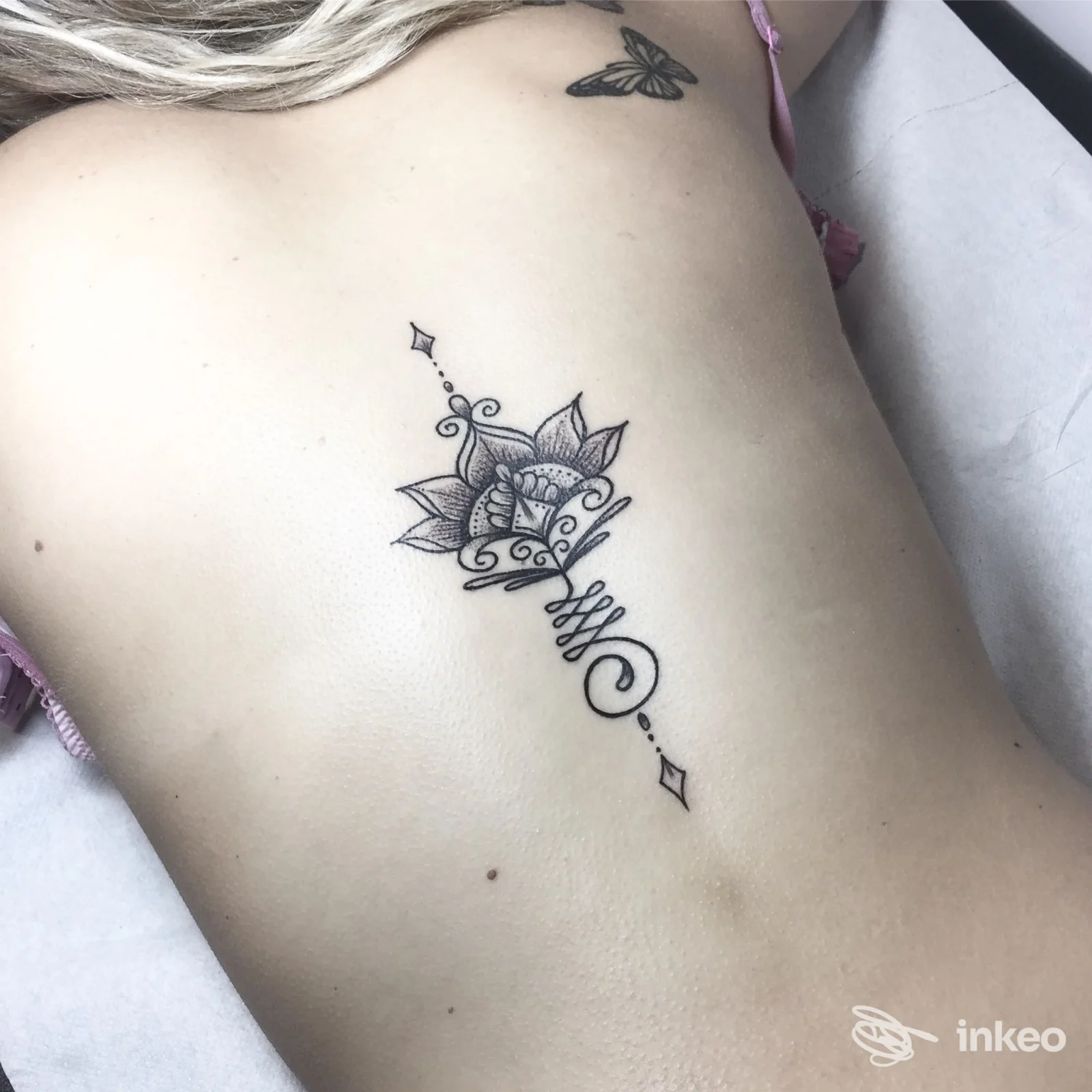 Tatuaggio ornamentale nero sul fianco, scatto ravvicinato — Hide and Seek • Tattoo Shop, Borgo San Lorenzo.