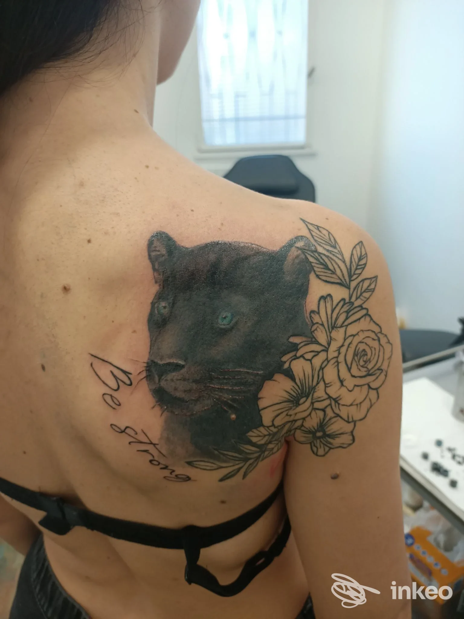 Tattoo sul dorso della spalla sinistra eseguito presso Galla Buzz Tattoo and More, Desio: felino scuro accanto a un bouquet di rose, senza elementi grafici esterni.