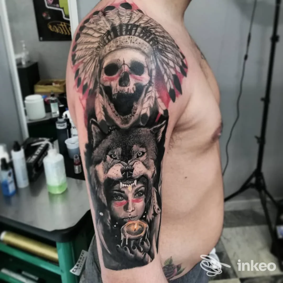 Ampia manica tatuata su spalla e braccio con teschio, lupo e volto femminile, lavoro fotografato presso Joe Tattoos Pisa.