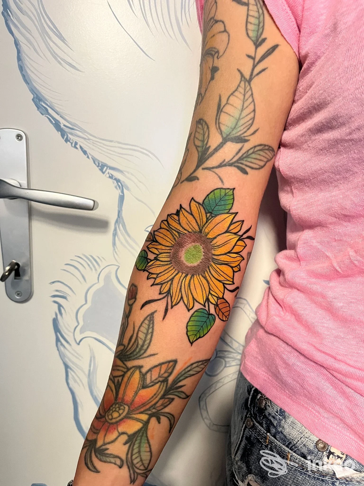Tatuaggio a colori di un girasole sull'avambraccio fotografato nello studio Inkdependent Pisa, Riglione-Oratoio.