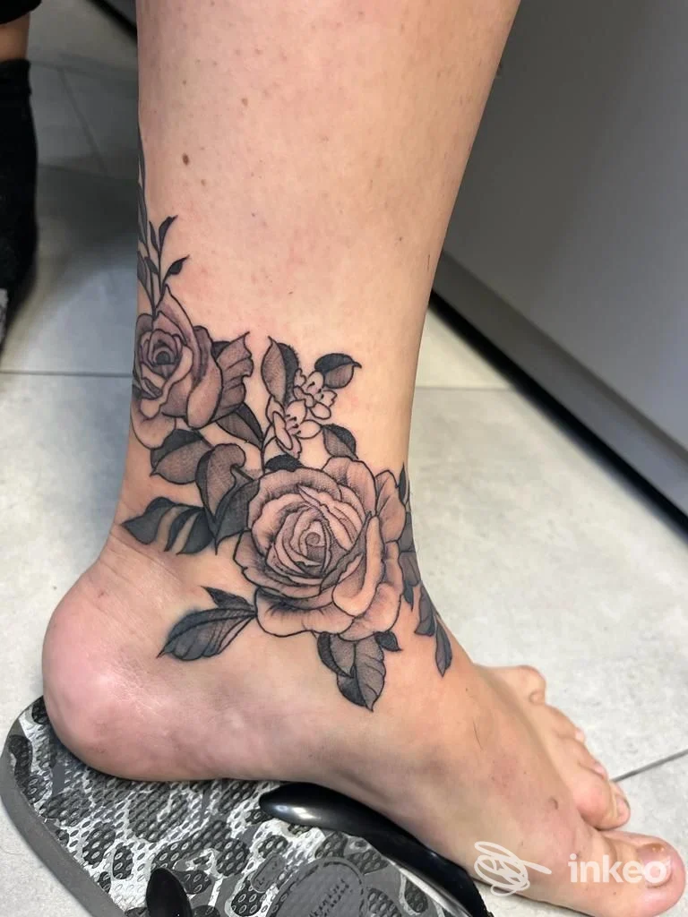 Tatuaggio di rose in bianco e nero sulla caviglia e collo del piede, lavoro di Inkdependent Pisa - Private Tattoo Studio, Riglione-Oratoio.