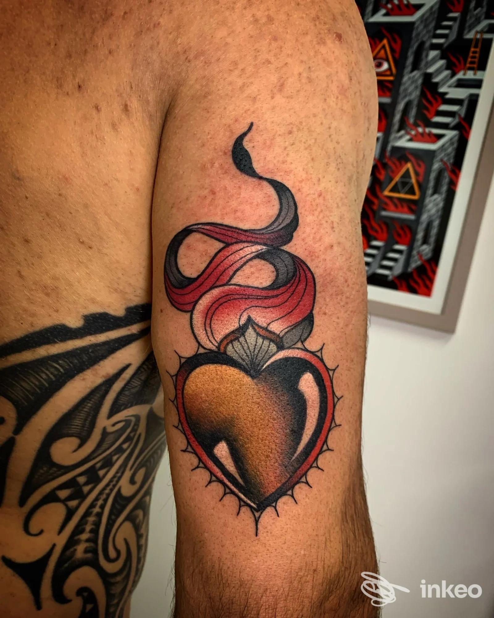Tatuaggio a forma di cuore fumante sul braccio superiore, foto fornita da La Torre dei Diavoli Tattoo Studio, Poppi.