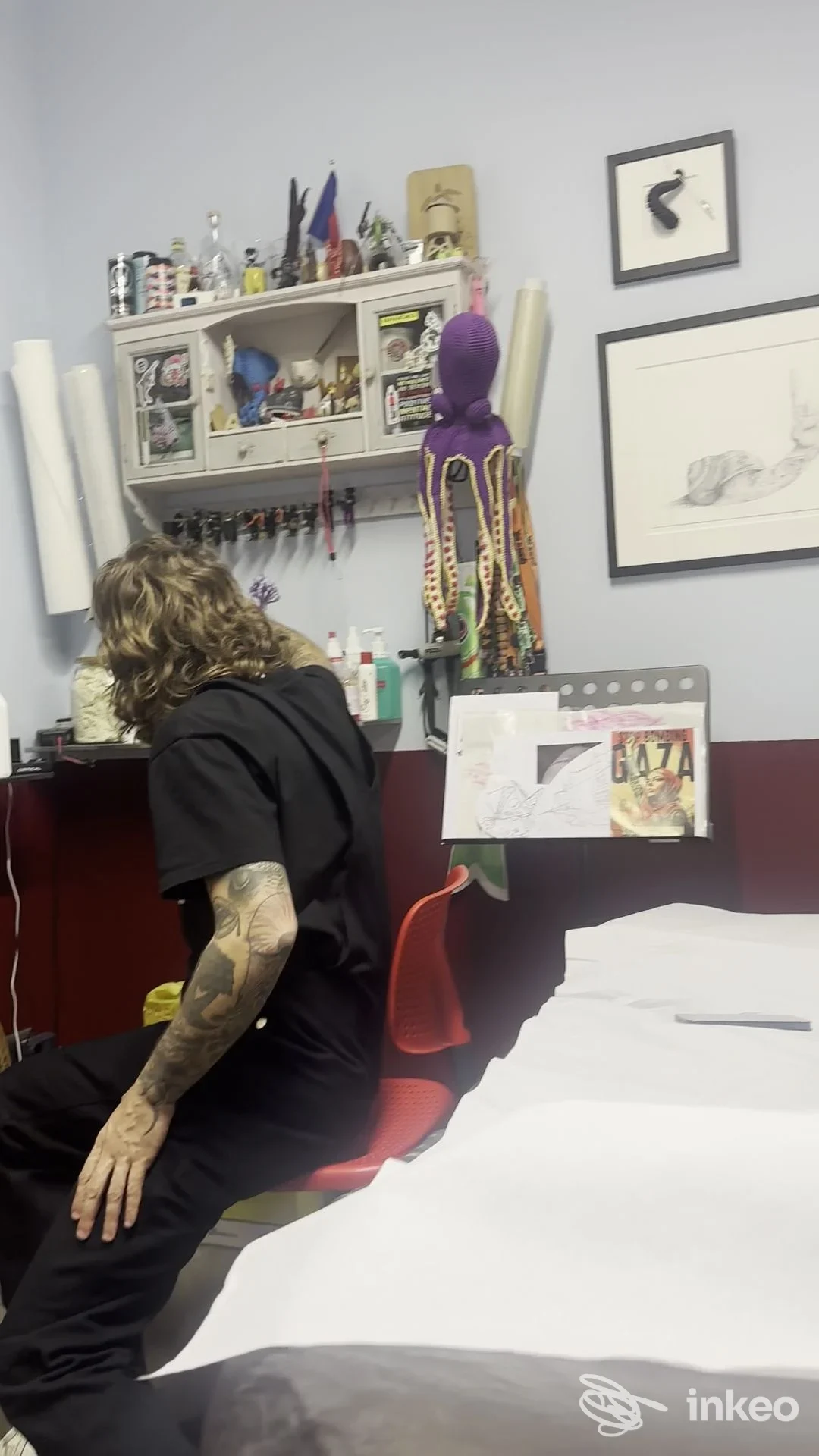 Interno dello studio Lacrimanera Tattoo Saloon a Firenze con un artista seduto e tatuaggi visibili sul braccio.
