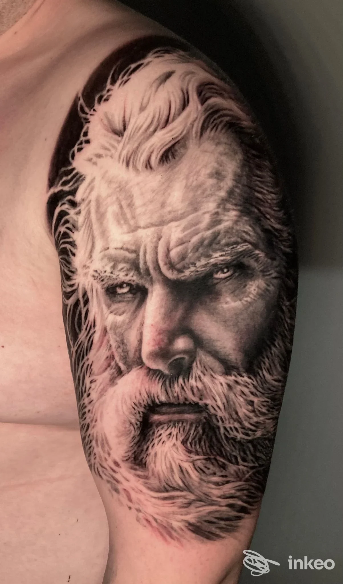 Tatuaggio realistico a mezza manica di un volto maschile su spalla, Lacrimanera Tattoo Saloon, Firenze.