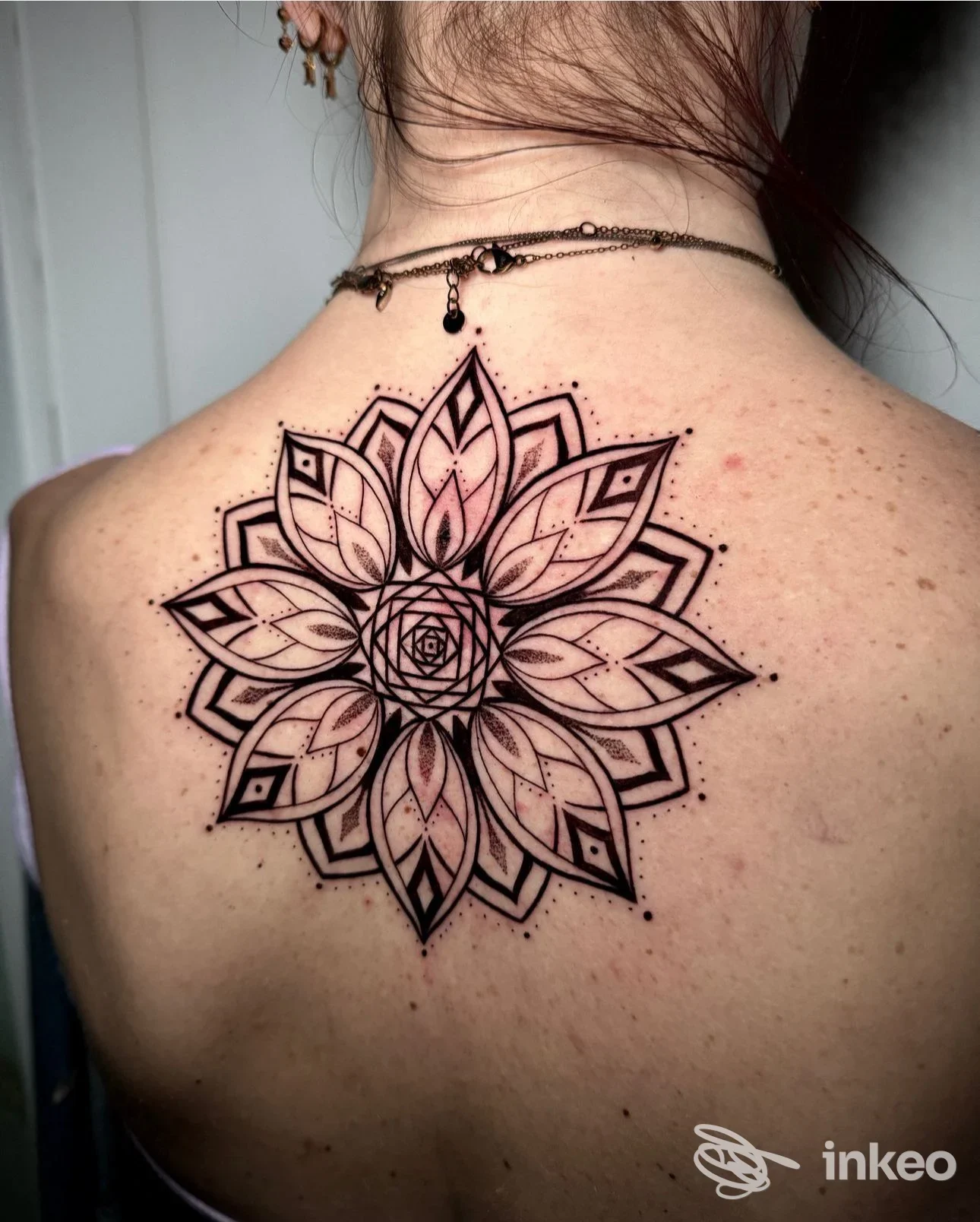 Grande tatuaggio mandala nero sul dorso superiore di una persona, lavoro eseguito da LIGHTHAUS TATTOO di Luca Natalini a Montecatini-Terme.